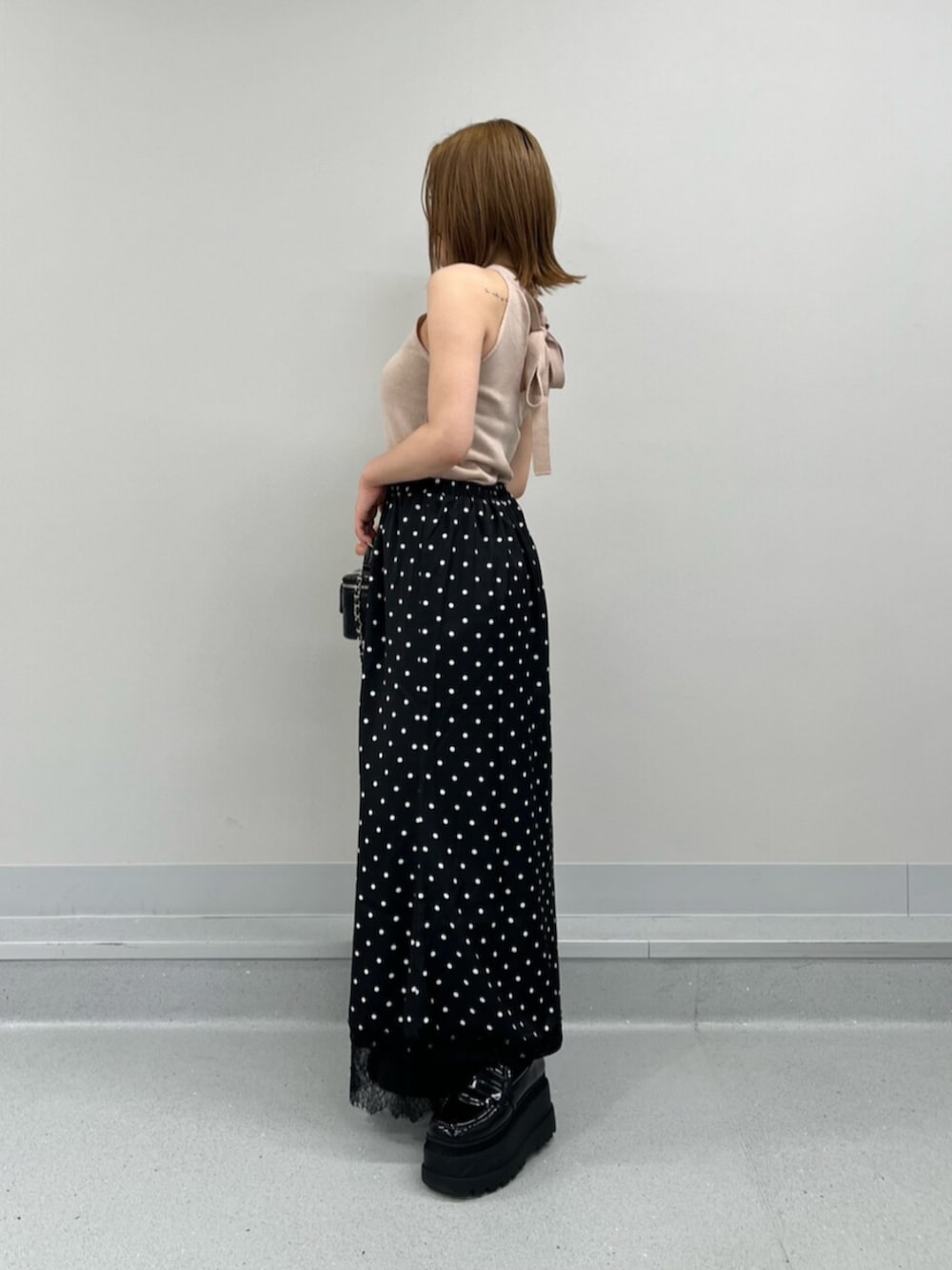 ブラック系のスカート、ピンク系のキャミソールを着用したレディースの夏コーディネートの2枚目の写真