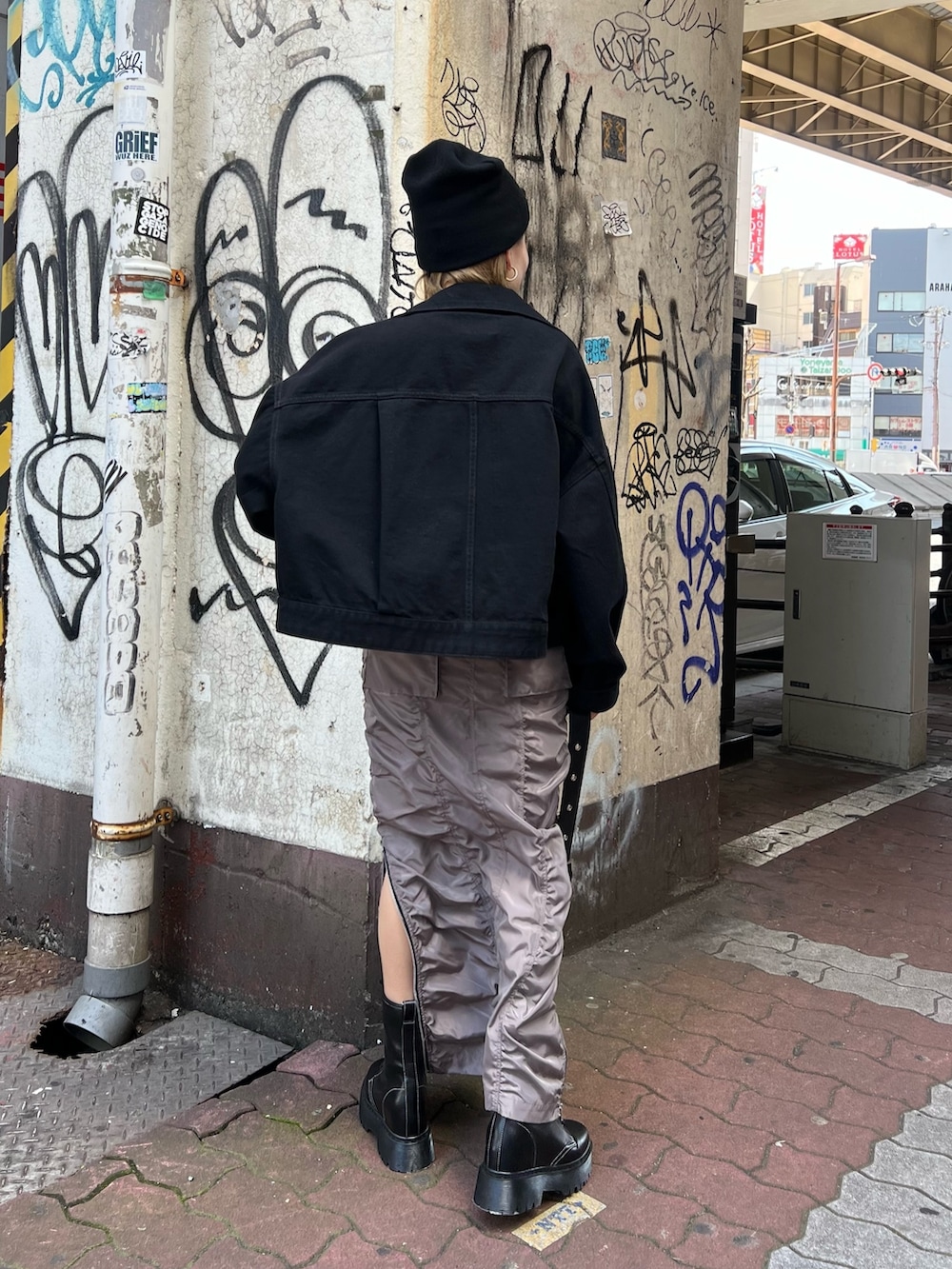 イエロー系のTシャツ/カットソー、ブラック系のデニムジャケット、グレー系のスカートを着用したレディースの春コーディネートの3枚目の写真