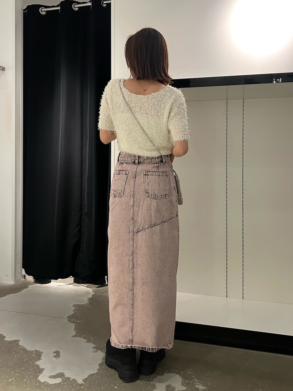 ホワイト系のニット/セーター、ピンク系のデニムスカート、ブラック系のブーツを着用したレディースの春コーディネートの2枚目の写真