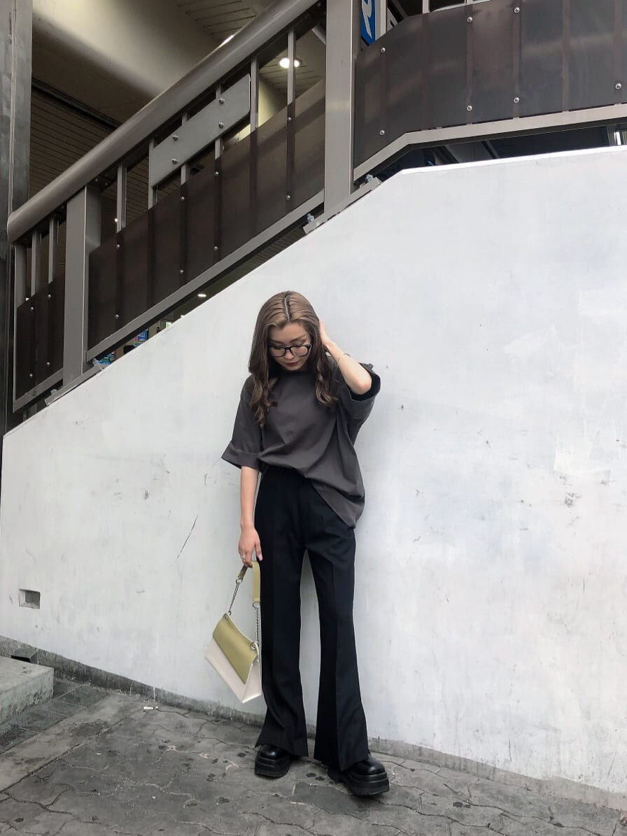 ブラック系のスラックス、ホワイト系のハンドバッグ、グレー系のTシャツ/カットソーを着用したレディースの春コーディネートの2枚目の写真