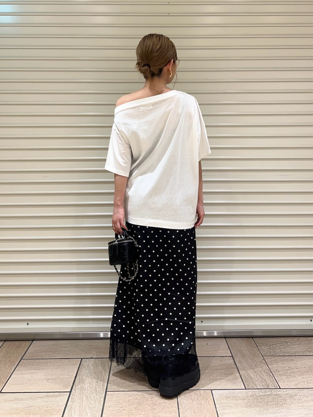 ホワイト系のTシャツ/カットソー、ブラック系のスカートを着用したレディースの夏コーディネートの3枚目の写真
