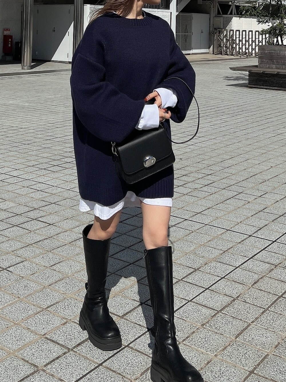 ブラック系のブーツ、ブラック系のショルダーバッグ、ホワイト系のTシャツ/カットソーを着用したレディースの秋コーディネートの5枚目の写真
