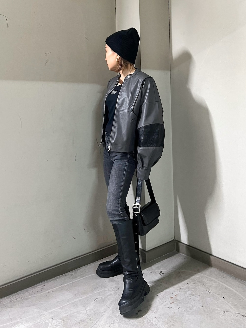 グレー系のブルゾン、ブラック系のTシャツ/カットソー、ブラック系のショルダーバッグを着用したレディースの冬コーディネートの2枚目の写真