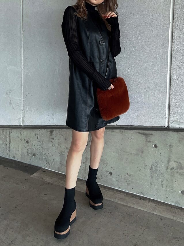 ブラック系のニット/セーター、ブラウン系のショルダーバッグ、ブラック系のワンピースを着用したレディースの秋コーディネートの6枚目の写真