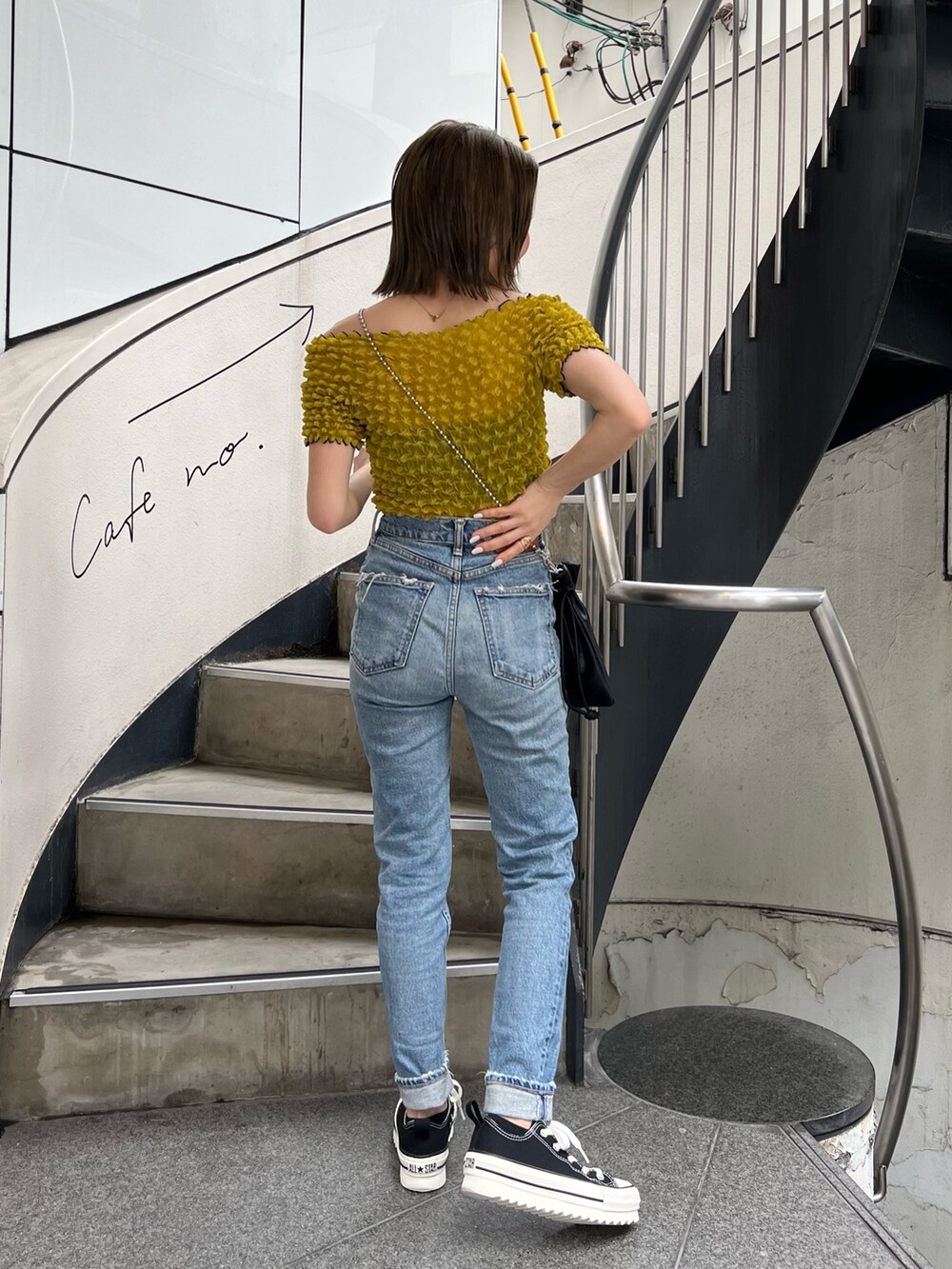 ブラック系のショルダーバッグ、イエロー系のシャツ/ブラウス、ブラック系のサングラスを着用したレディースの春コーディネートの4枚目の写真