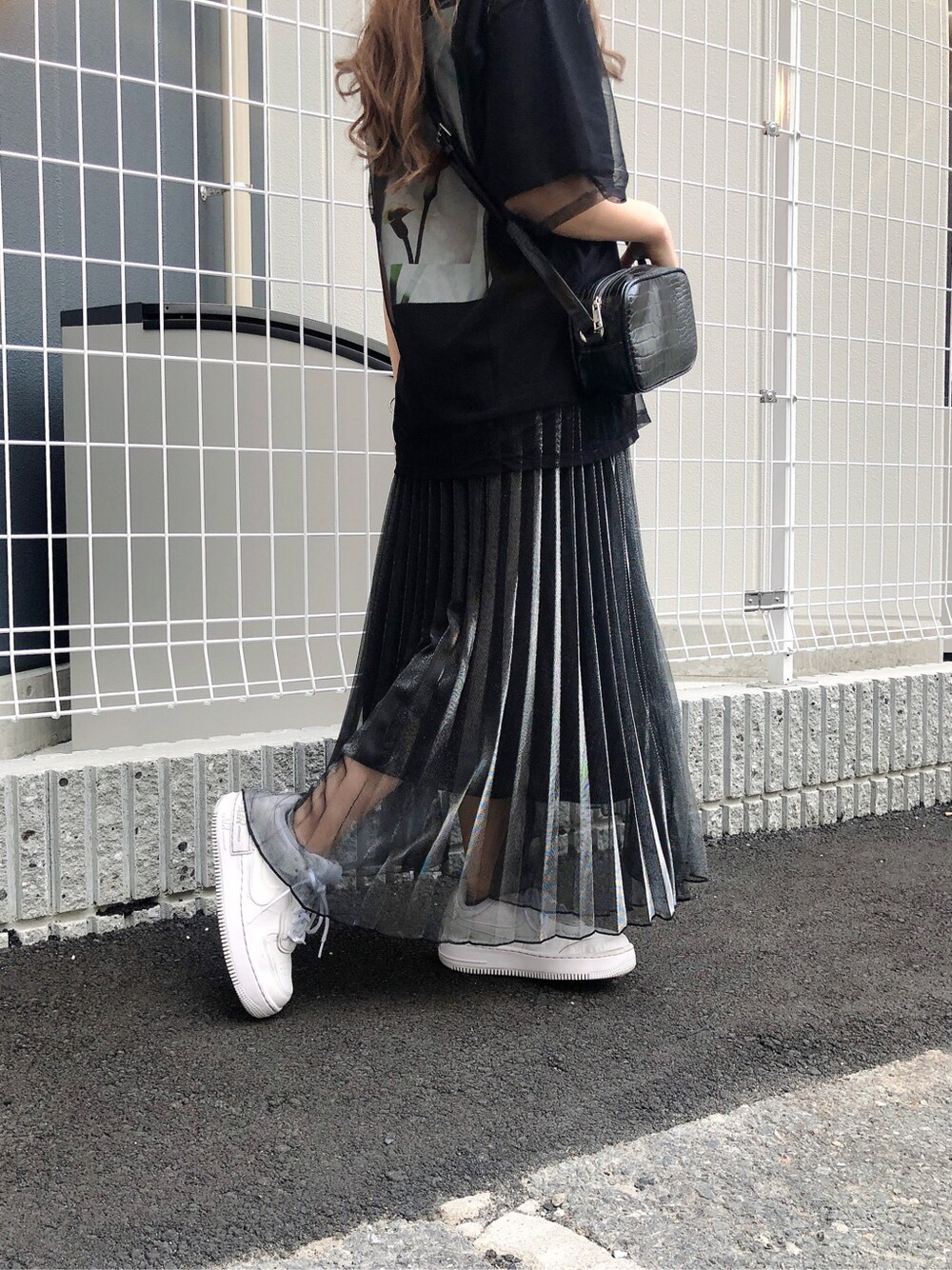 ブラック系のショルダーバッグ、ブラック系のスカート、ブラック系のTシャツ/カットソーを着用したレディースの春コーディネートの2枚目の写真