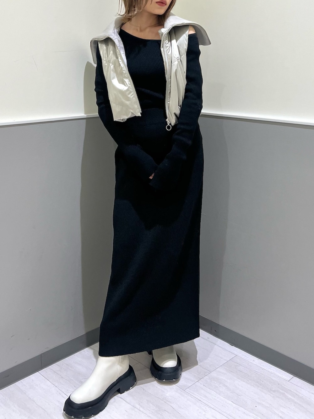 ホワイト系のブーツ、ブラック系のスカート、シルバー系のブルゾンを着用したレディースの冬コーディネートの5枚目の写真