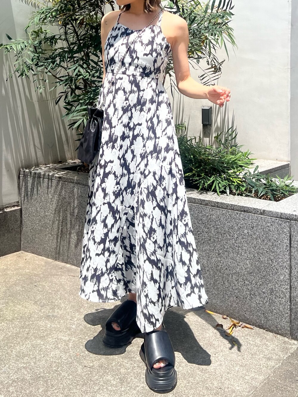 ホワイト系のワンピース、ブラック系のショルダーバッグ、ブラック系のサンダルを着用したレディースの夏コーディネートの5枚目の写真