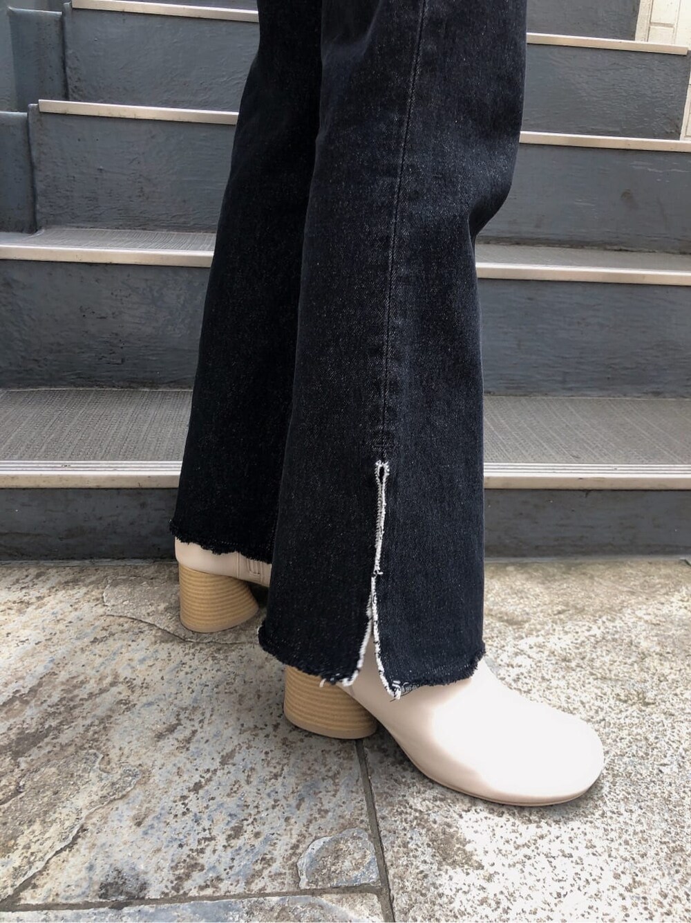 ホワイト系のブーツ、パープル系のニット/セーター、ブラック系のデニムパンツを着用したレディースの秋コーディネートの6枚目の写真