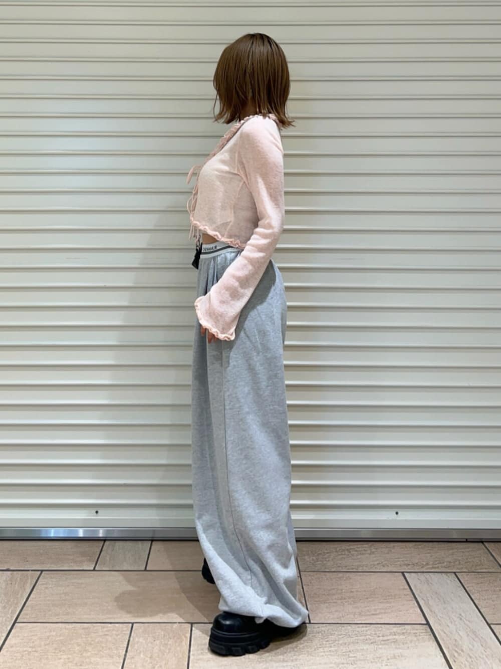 グレー系のその他パンツ、ピンク系のニット/セーターを着用したレディースの春コーディネートの2枚目の写真