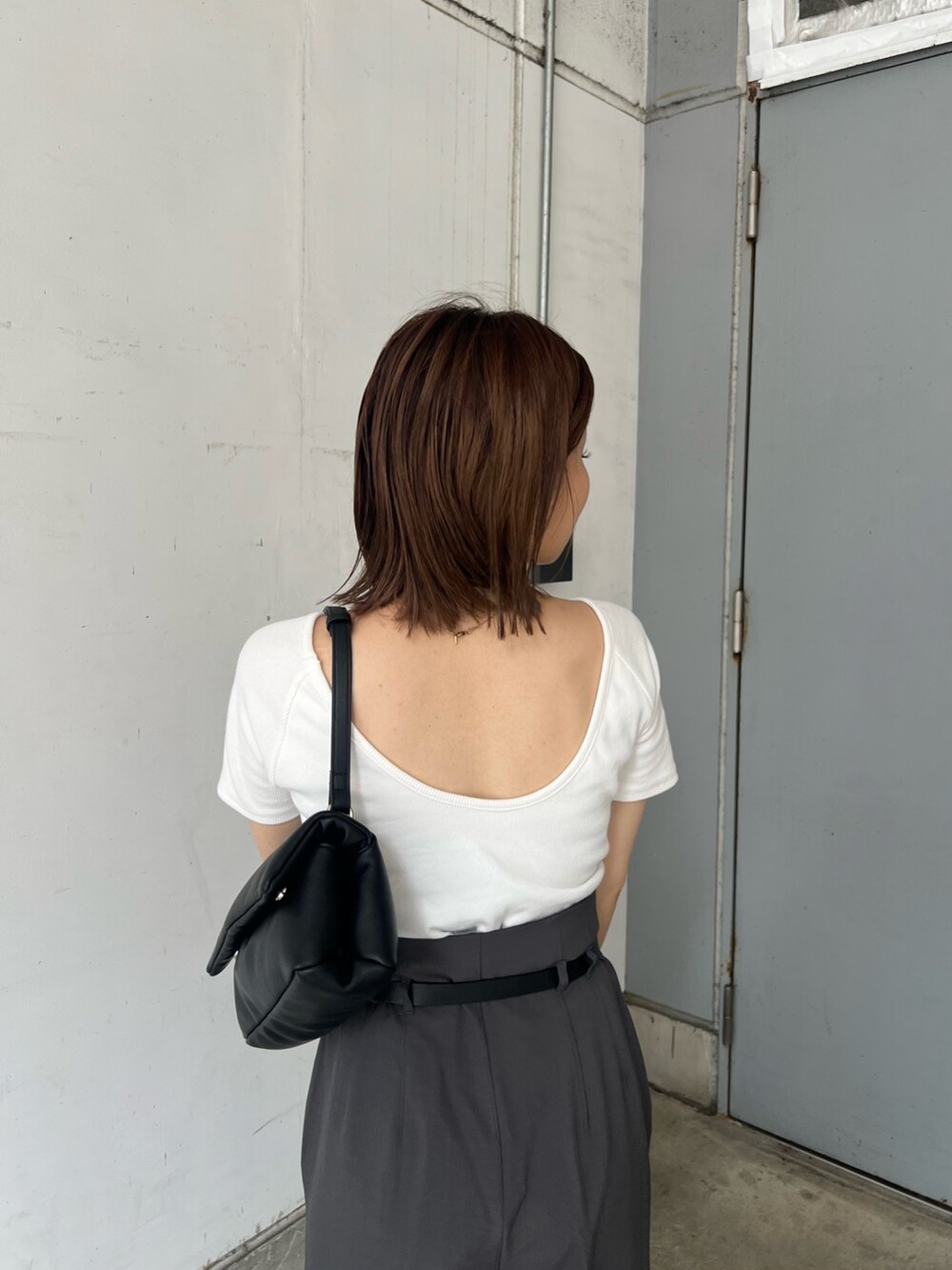 ホワイト系のTシャツ/カットソー、グレー系のその他パンツ、ブラック系のハンドバッグを着用したレディースの夏コーディネートの6枚目の写真
