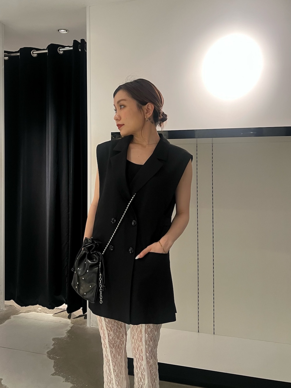 ブラック系のベスト、ホワイト系のその他パンツ、ブラック系のサンダルを着用したレディースの春コーディネートの4枚目の写真