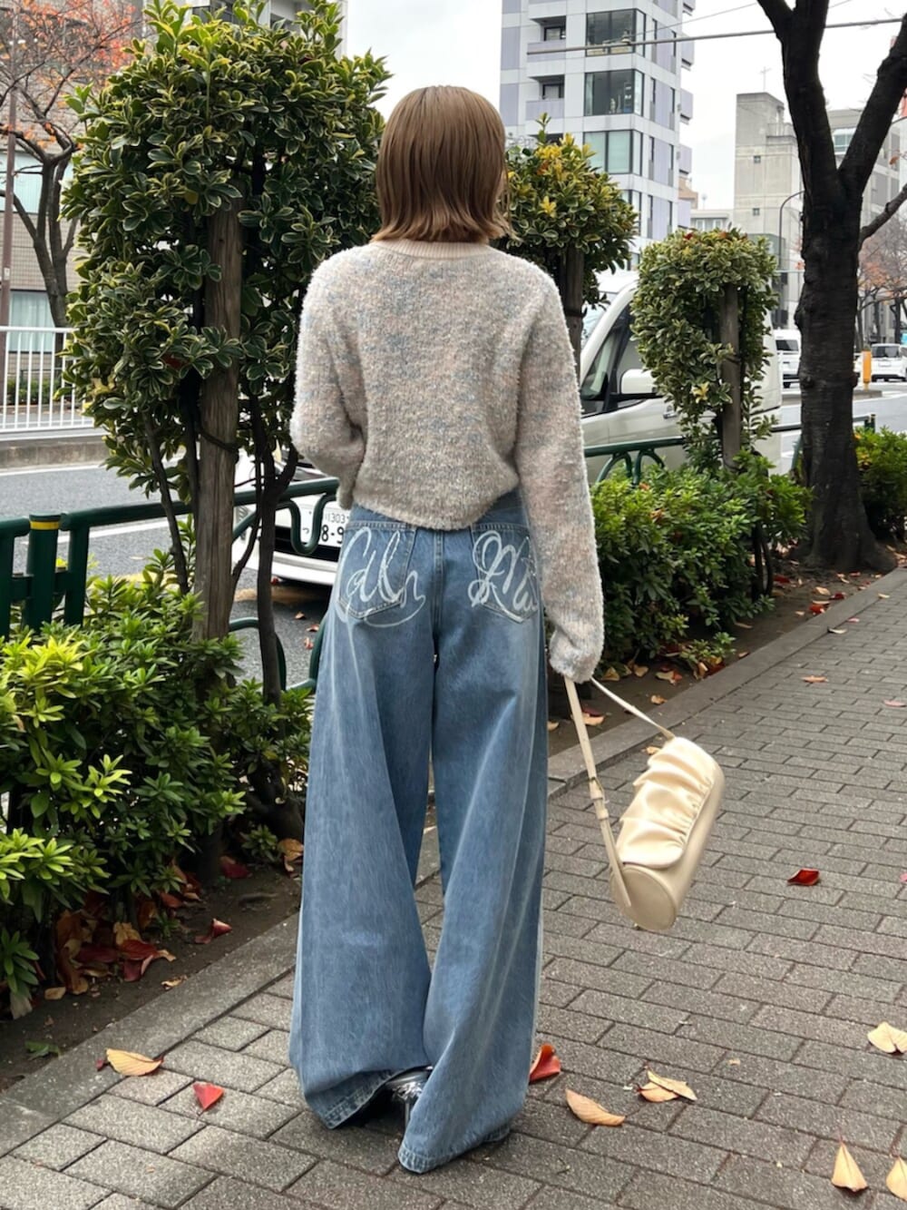 イエロー系のハンドバッグ、ブルー系のその他パンツ、その他のカーディガン/ボレロを着用したレディースの冬コーディネートの3枚目の写真