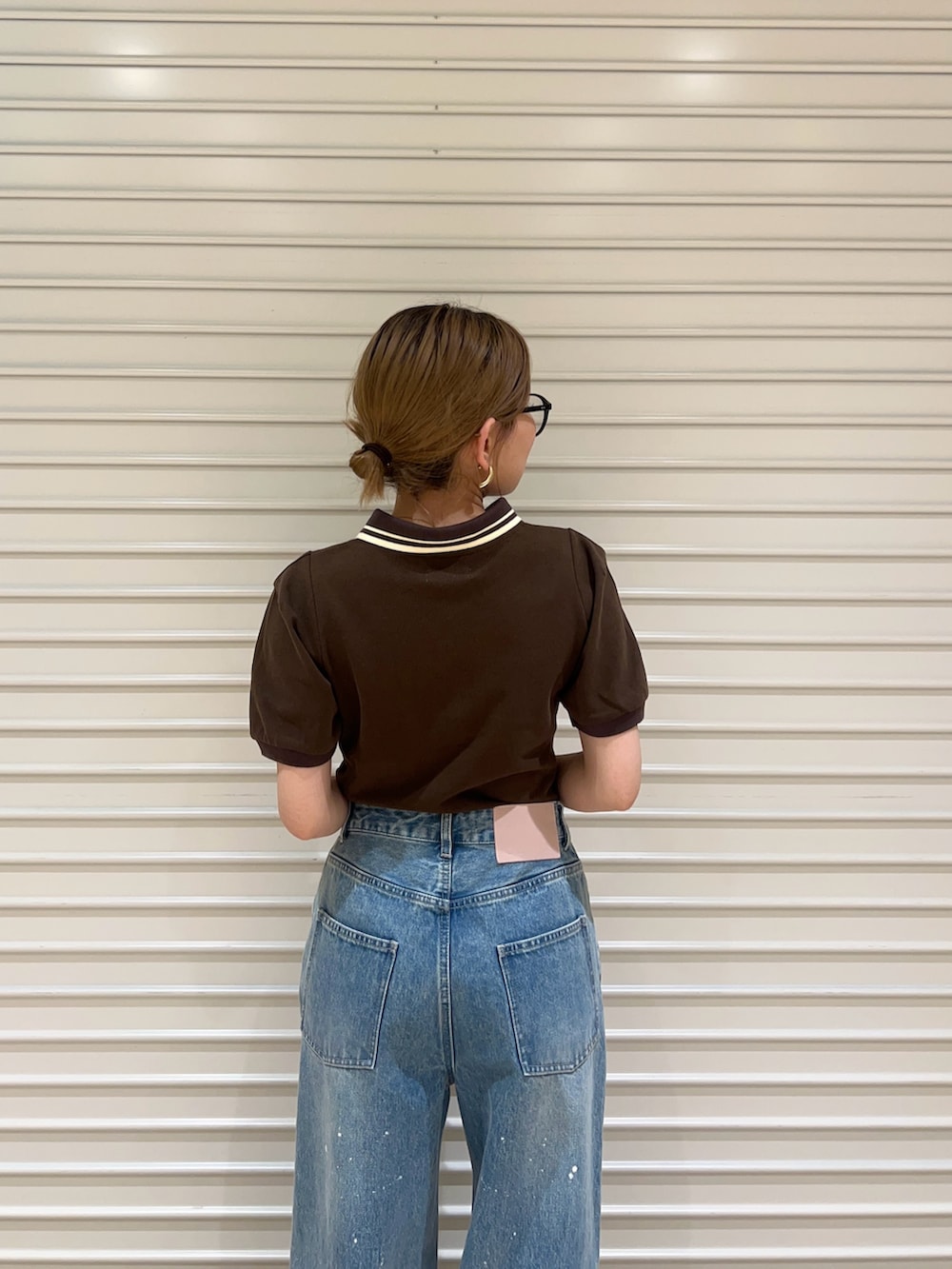 ブルー系のデニムパンツ、ブラウン系のサンダル、ブラウン系のTシャツ/カットソーを着用したレディースの春コーディネートの5枚目の写真