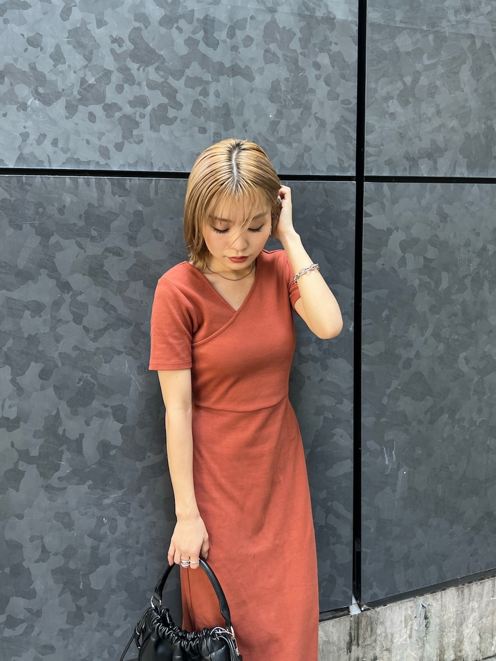 オレンジ系のワンピース、ブラック系のサンダルを着用したレディースの夏コーディネートの5枚目の写真