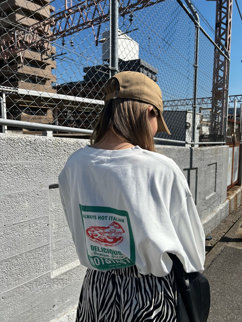 ブラック系のローファー、ホワイト系のTシャツ/カットソー、ホワイト系のスカートを着用したレディースの春コーディネートの5枚目の写真
