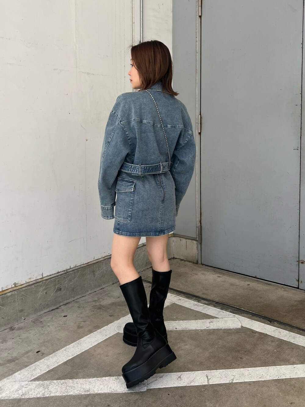 ブラック系のショルダーバッグ、ブラック系のブーツ、その他のTシャツ/カットソーを着用したレディースの夏コーディネートの2枚目の写真