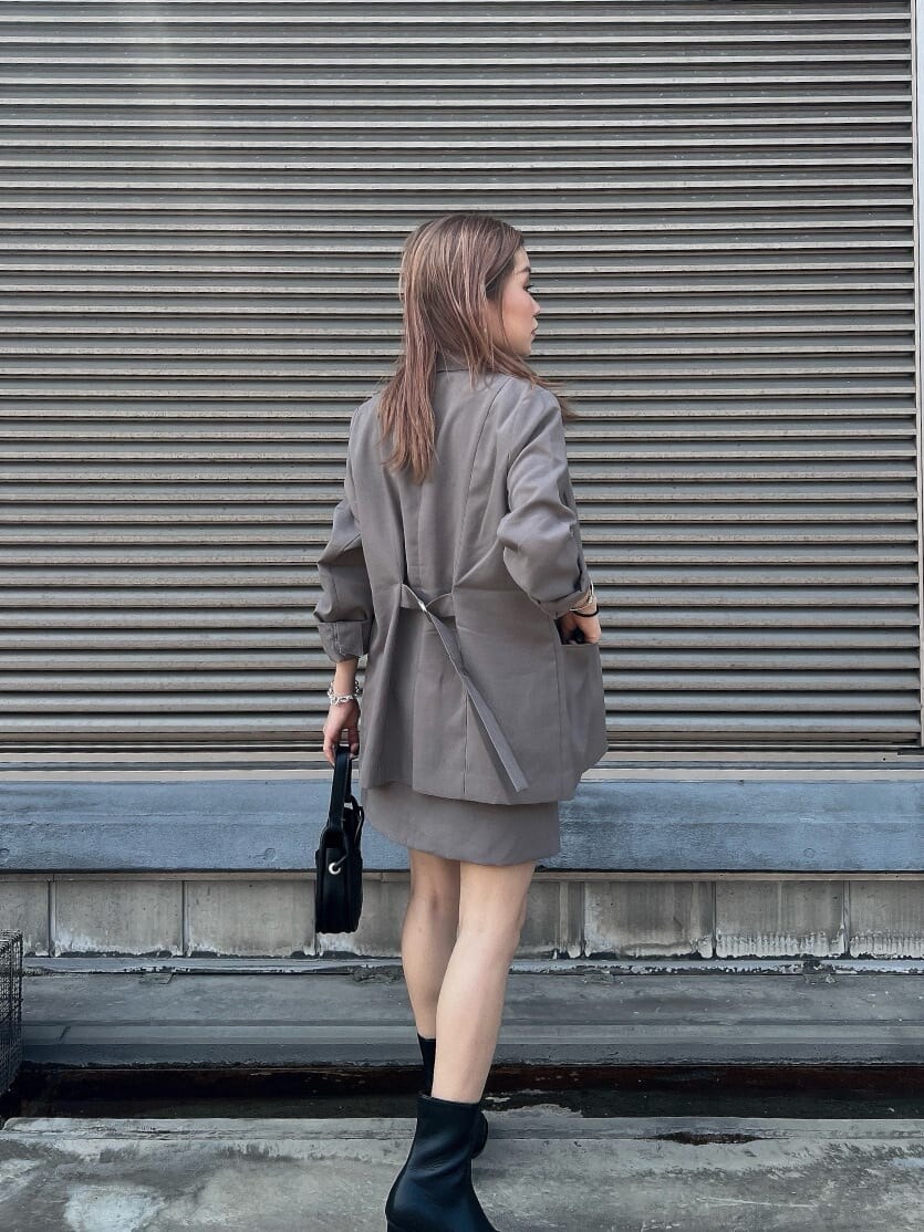 ホワイト系のタンクトップ、グレー系のテーラードジャケット、グレー系のスカートを着用したレディースの夏コーディネートの7枚目の写真