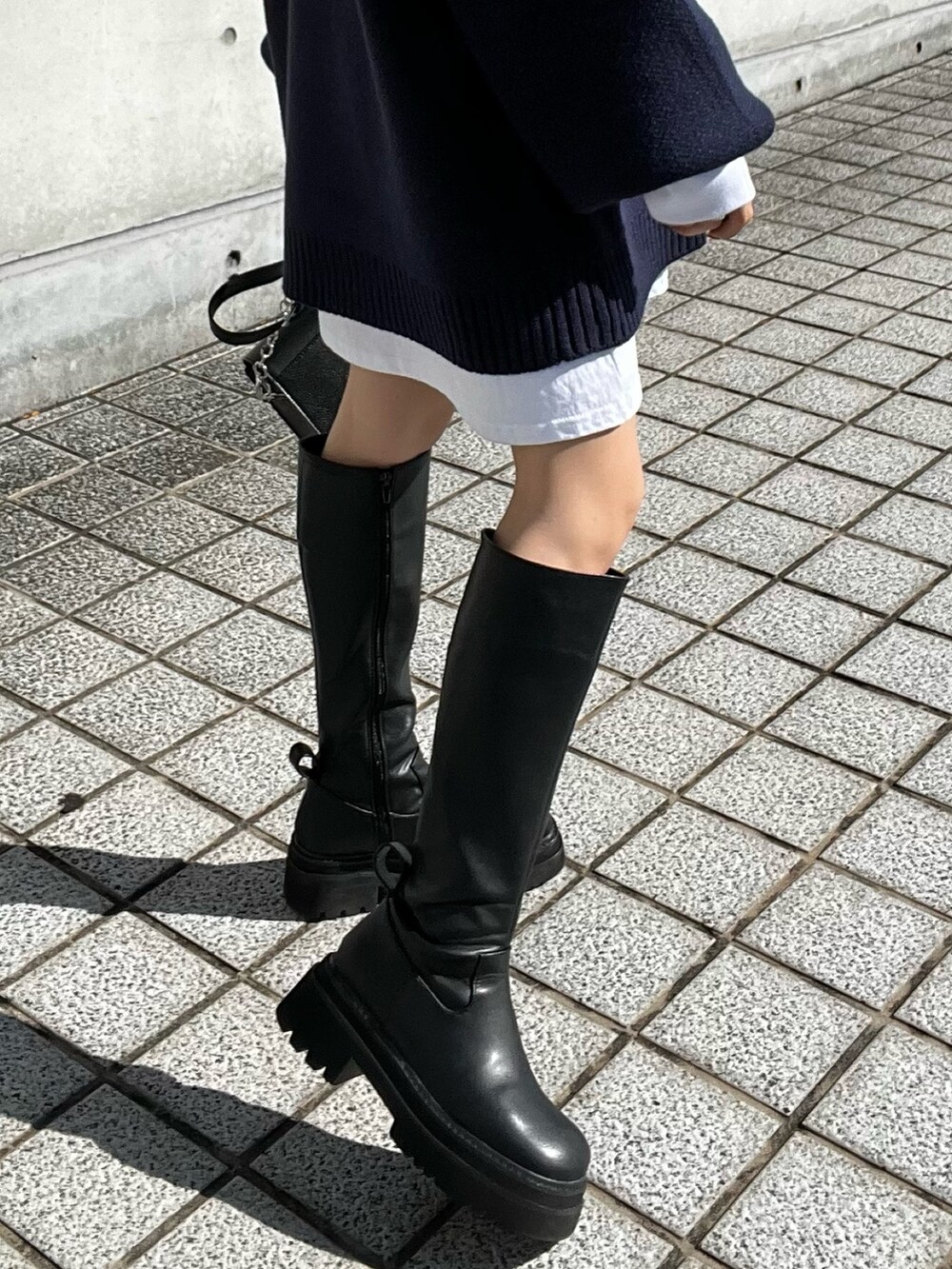 ブラック系のブーツ、ブラック系のショルダーバッグ、ホワイト系のTシャツ/カットソーを着用したレディースの秋コーディネートの7枚目の写真