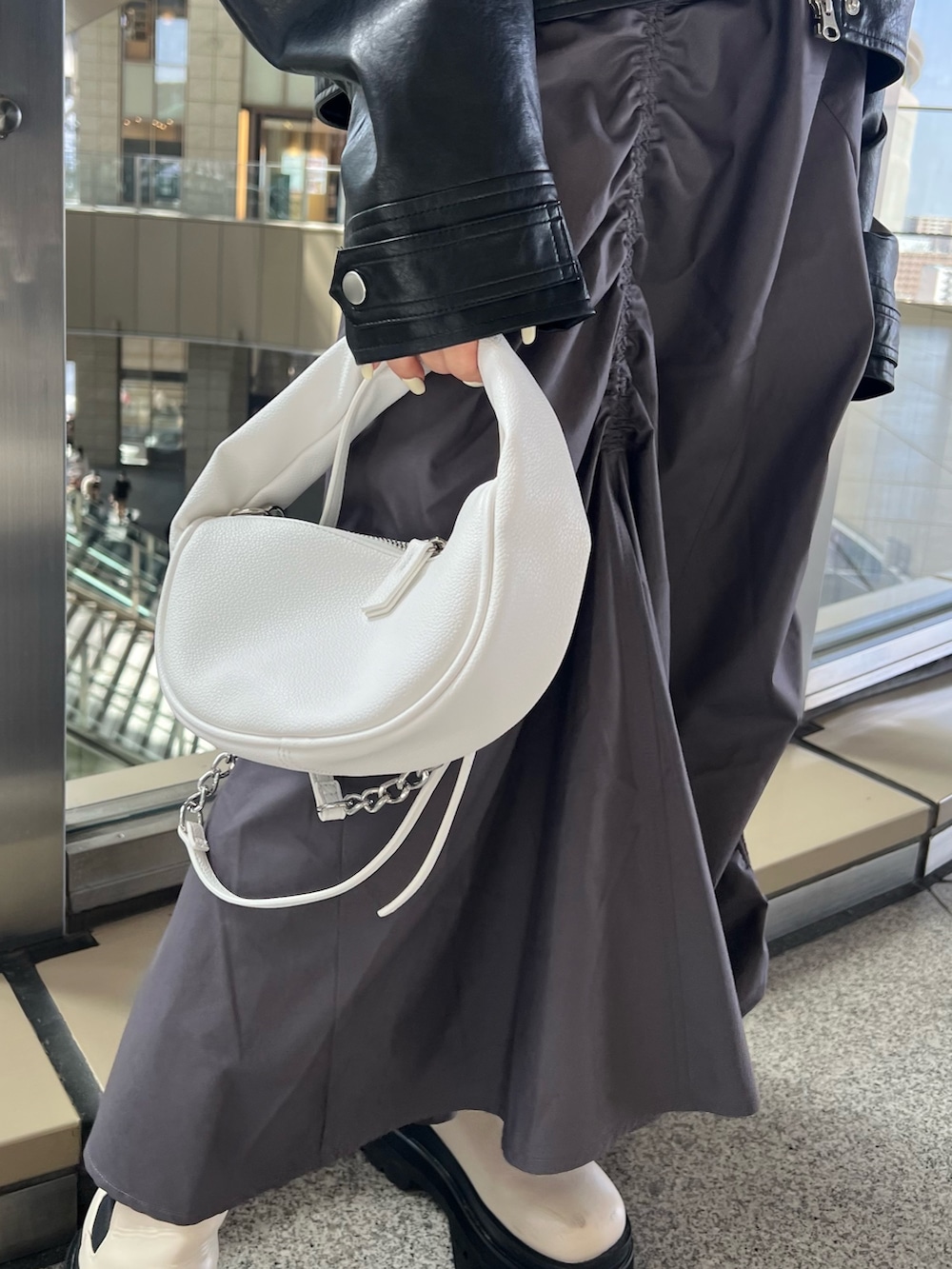 ブラック系のブルゾン、ブラウン系のニット/セーター、グレー系のスカートを着用したレディースの春コーディネートの8枚目の写真