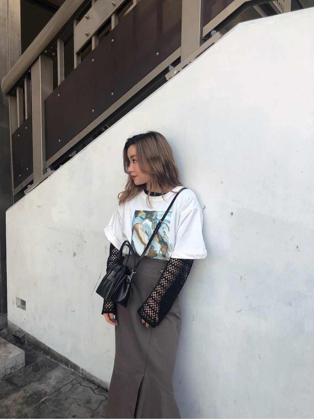 グレー系のスカート、ブラック系のハンドバッグ、ホワイト系のTシャツ/カットソーを着用したレディースの春コーディネートの5枚目の写真