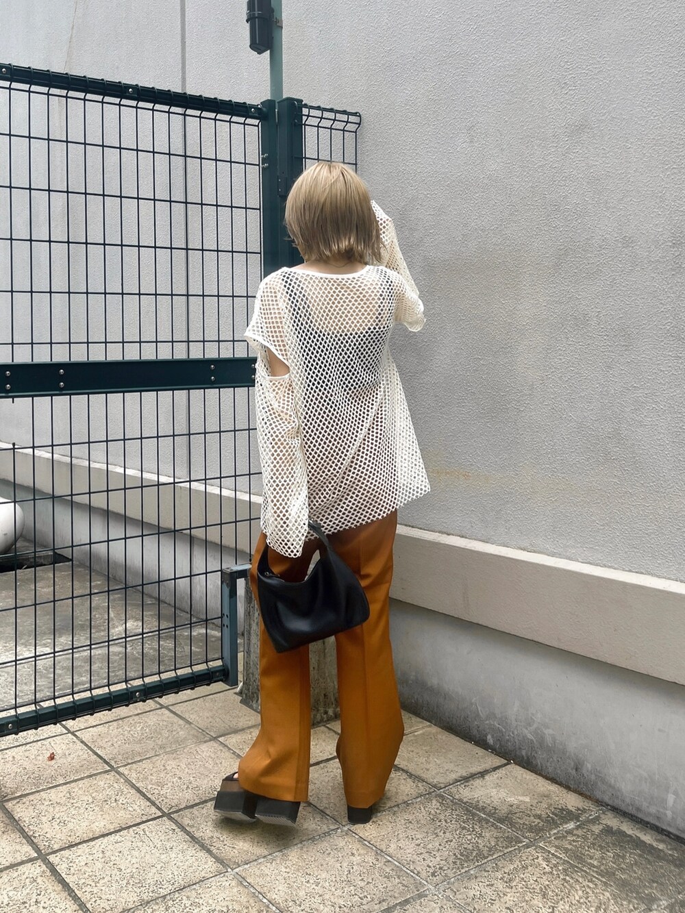 オレンジ系のその他パンツ、ブラック系のサンダル、ブラック系のハンドバッグを着用したレディースの夏コーディネートの3枚目の写真