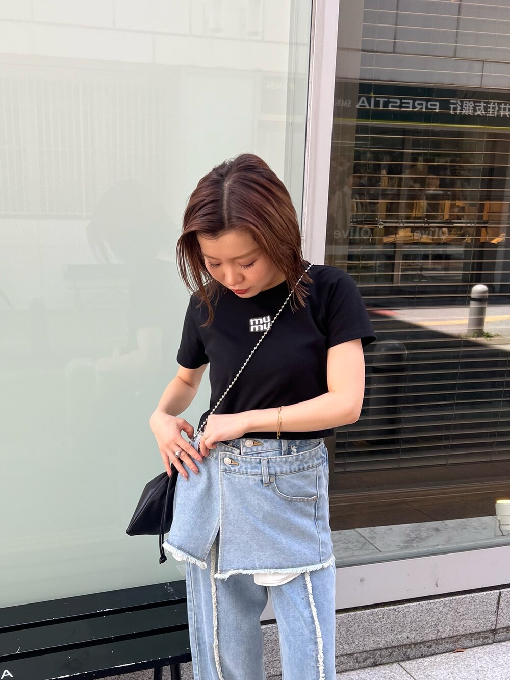 ブラック系のTシャツ/カットソー、ブルー系のデニムパンツ、ブラック系のショルダーバッグを着用したレディースの夏コーディネートの5枚目の写真