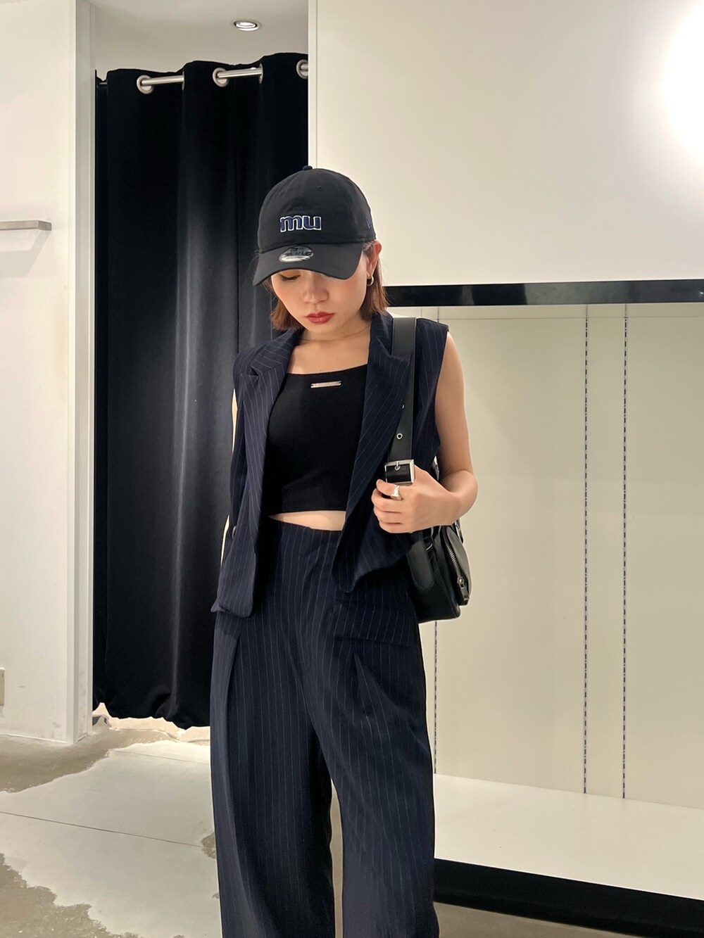 ブルー系のベスト、ブルー系のその他パンツ、ブラック系のキャミソールを着用したレディースの夏コーディネートの5枚目の写真