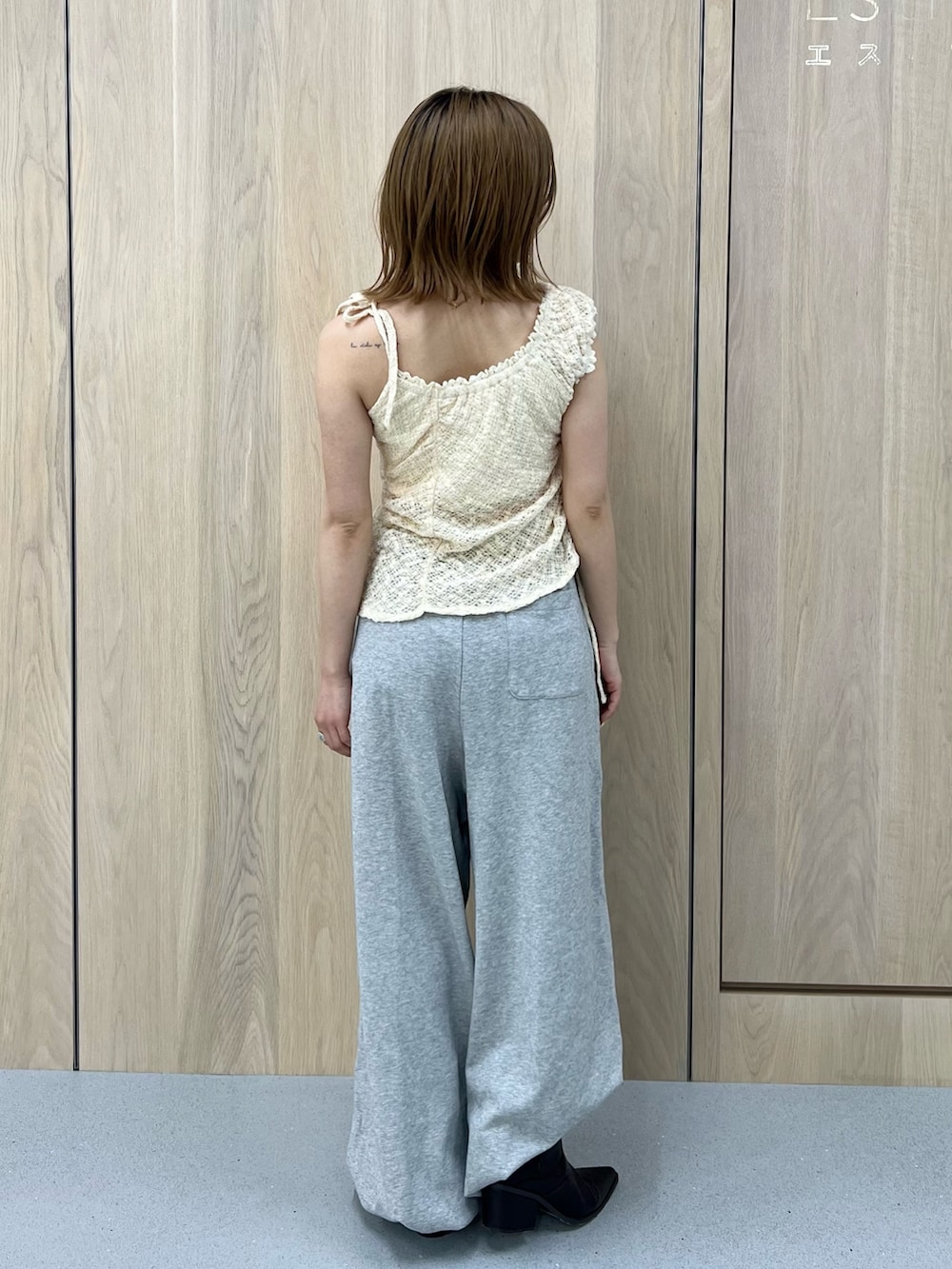 グレー系のスウェットパンツ、ホワイト系のタンクトップ、ブラウン系のブーツを着用したレディースの春コーディネートの3枚目の写真