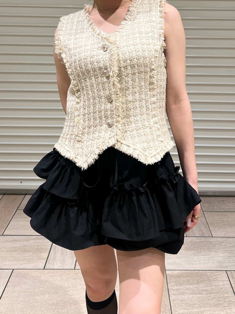 ベージュ系のベスト、ブラック系のその他パンツを着用したレディースの夏コーディネートの6枚目の写真