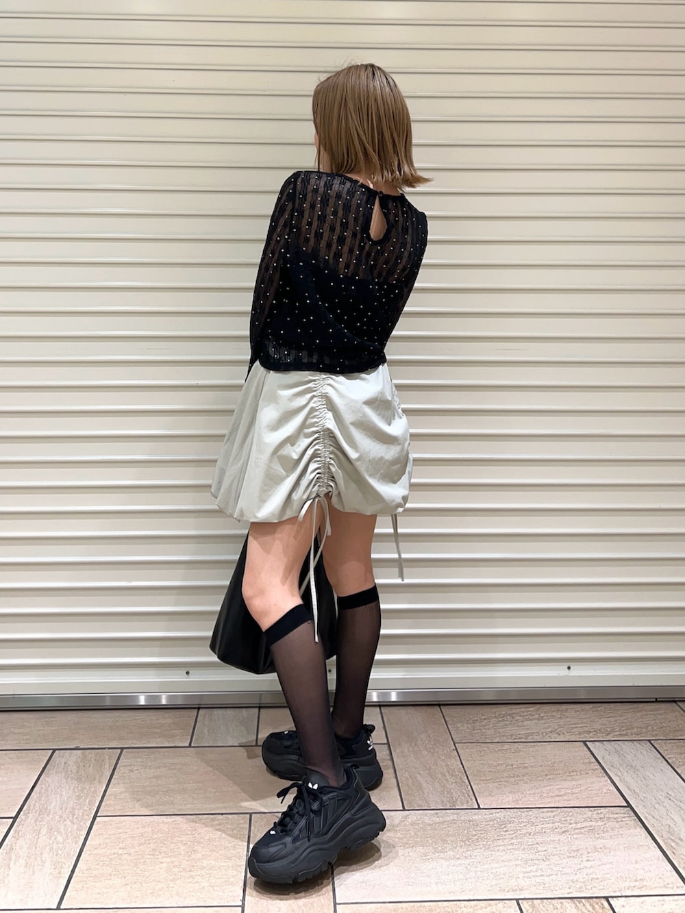 ブラック系のTシャツ/カットソー、グリーン系のスカートを着用したレディースの春コーディネートの2枚目の写真