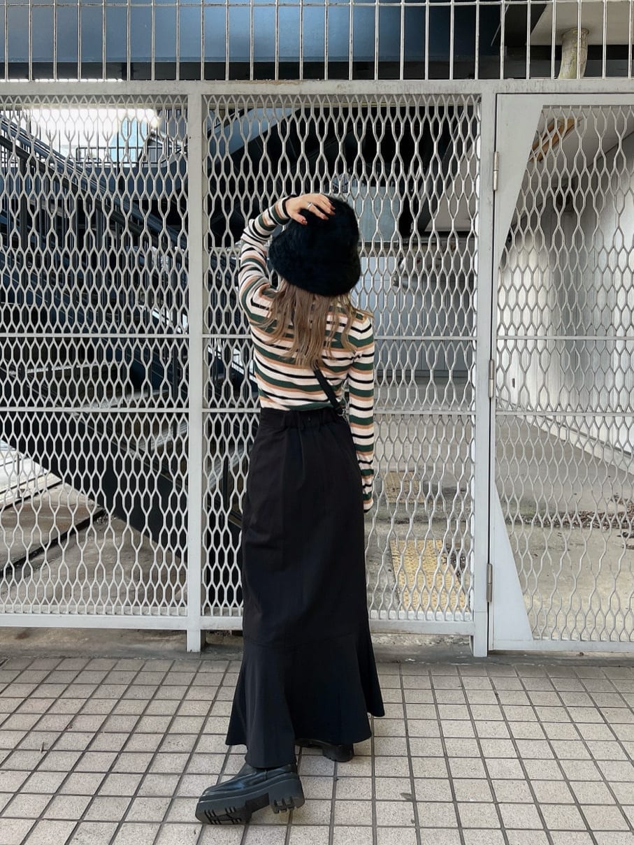 ブラック系のブーツ、ブラック系のショルダーバッグ、ブラック系のスカートを着用したレディースの秋コーディネートの3枚目の写真