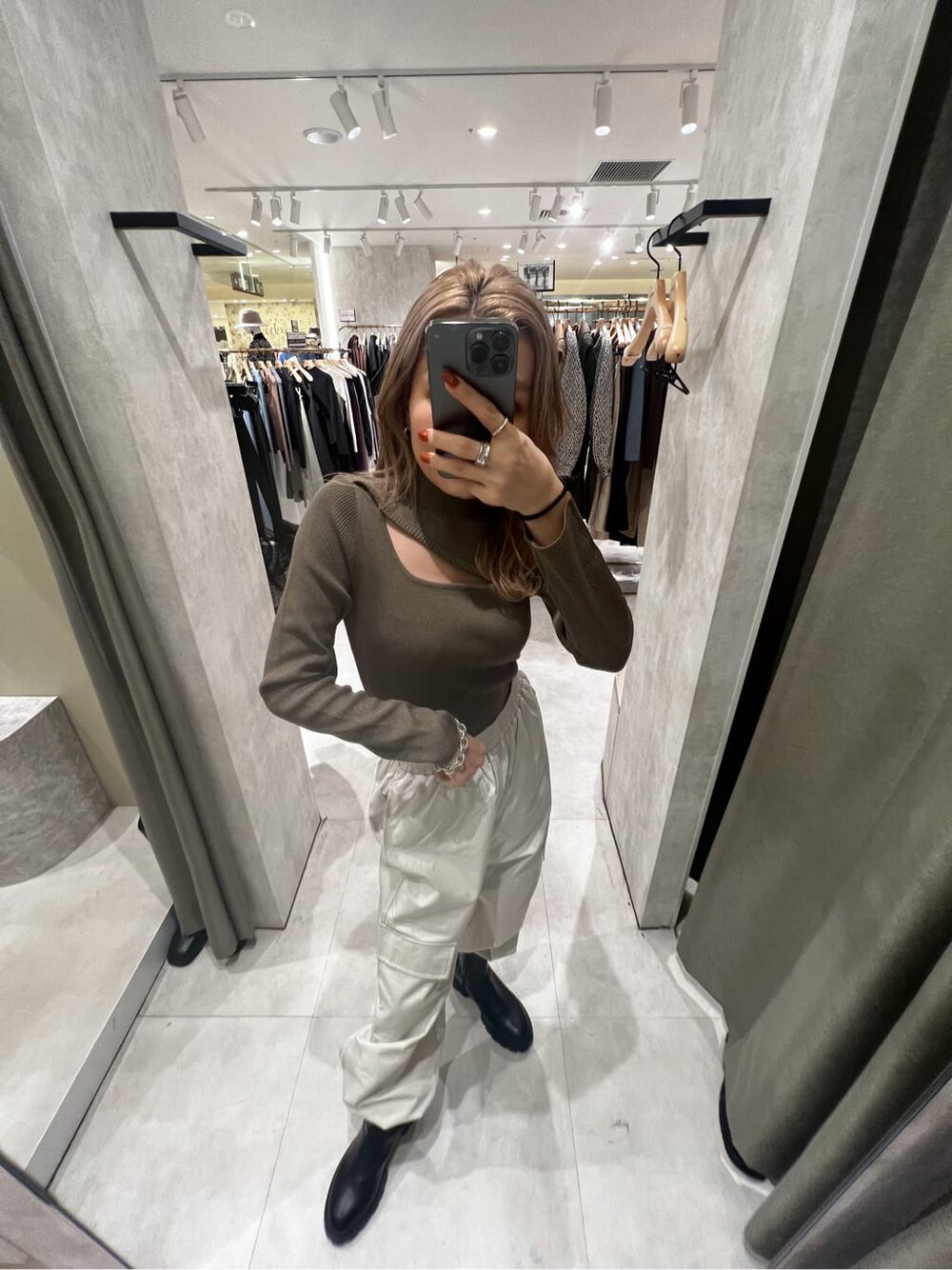 ブラック系のブーツ、ブラウン系のニット/セーター、ホワイト系のカーゴパンツを着用したレディースの秋コーディネートの2枚目の写真