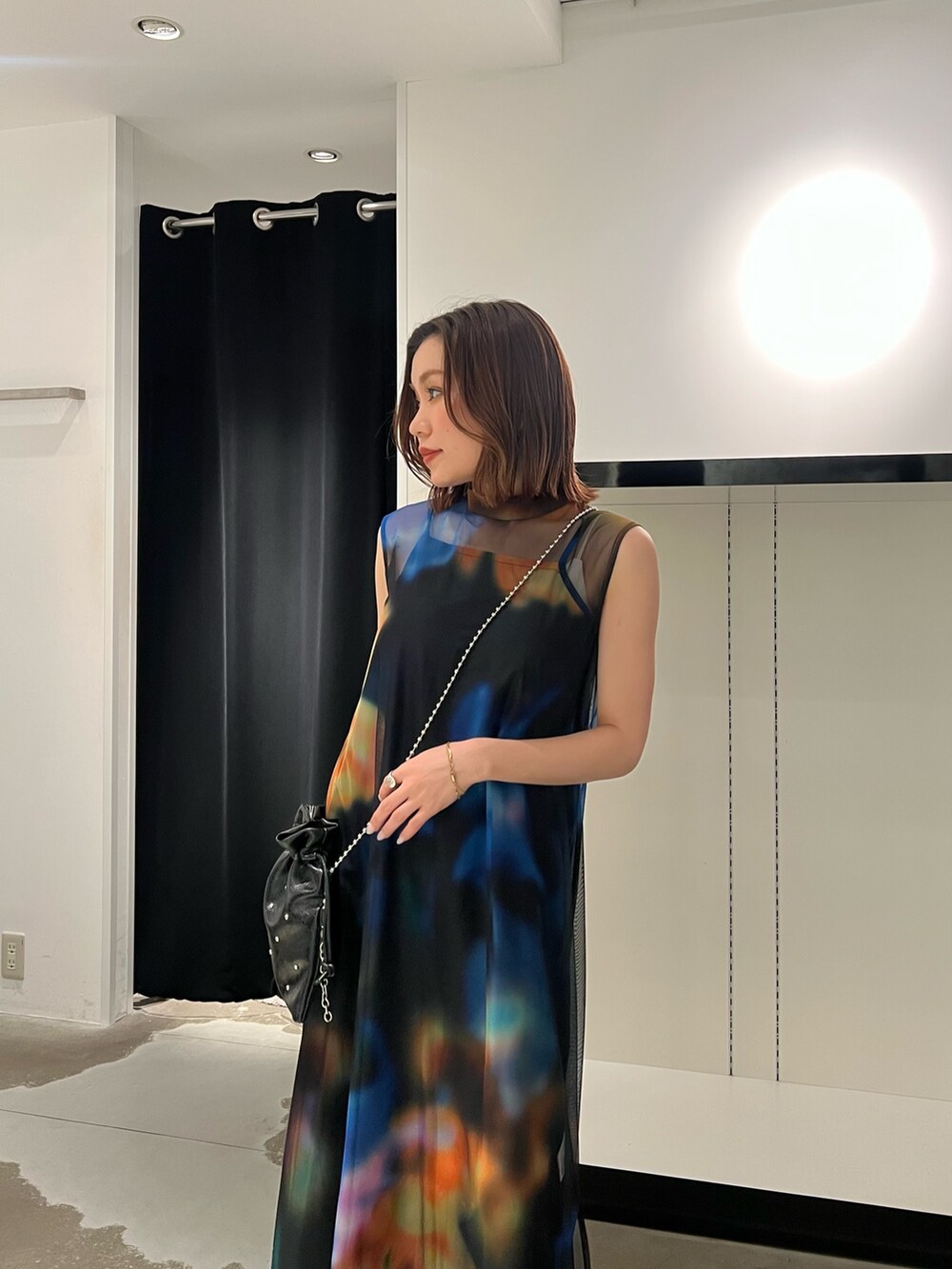 ブラック系のワンピース、ブラック系のサンダル、ブラック系のショルダーバッグを着用したレディースの春コーディネートの4枚目の写真