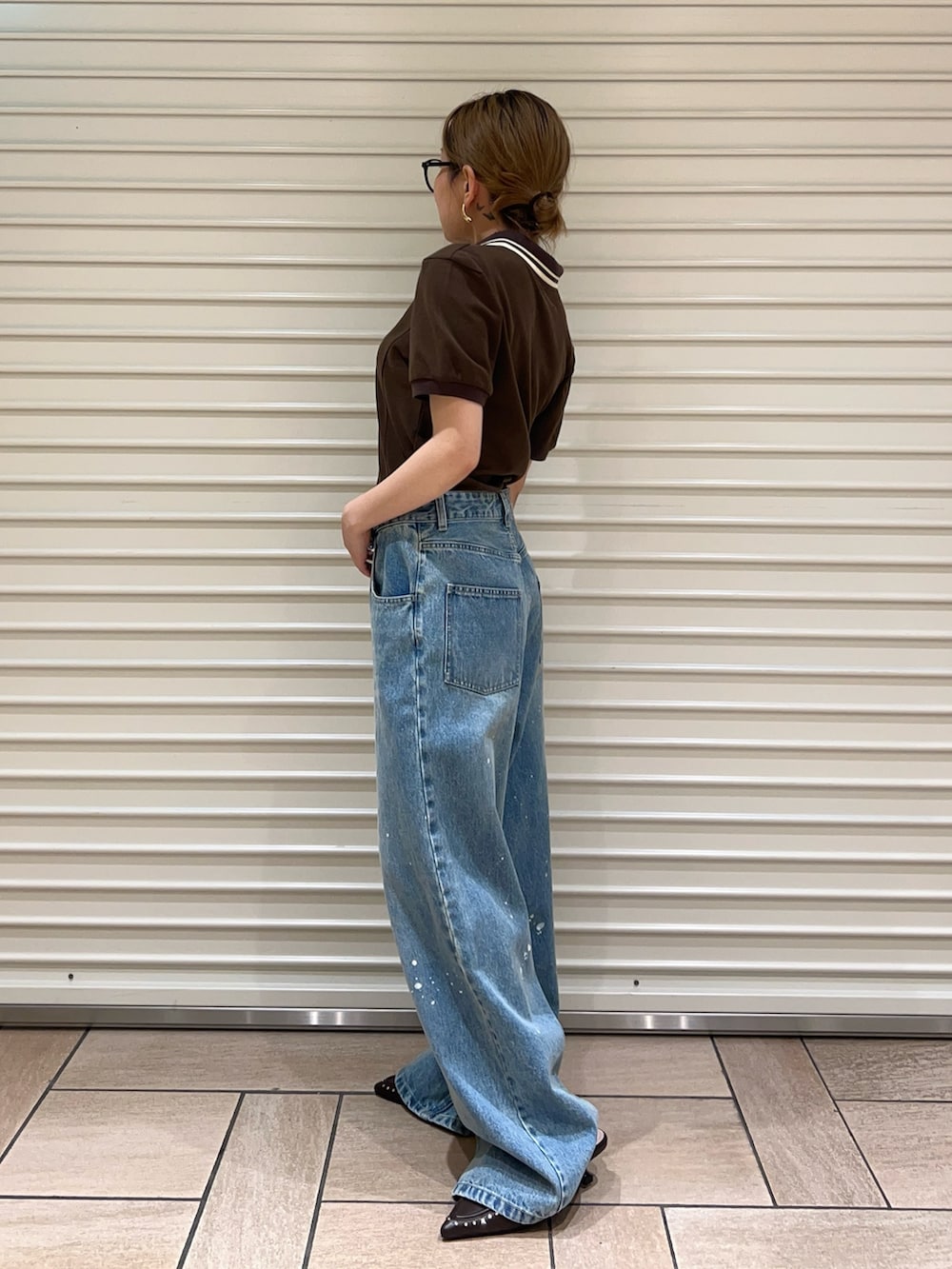 ブルー系のデニムパンツ、ブラウン系のサンダル、ブラウン系のTシャツ/カットソーを着用したレディースの春コーディネートの2枚目の写真