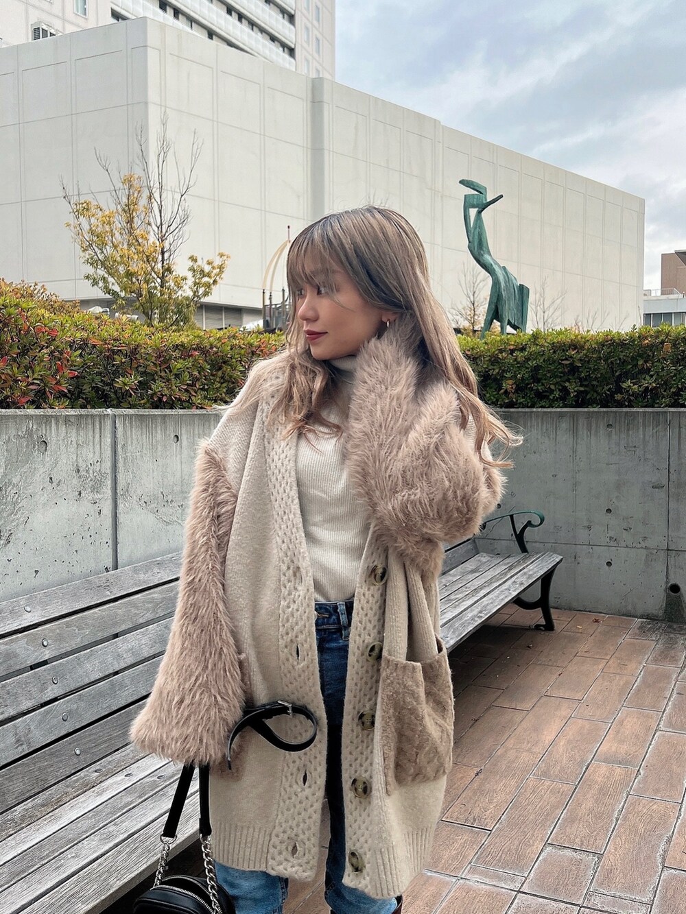 ホワイト系のニット/セーター、ベージュ系のカーディガン/ボレロ、ブラウン系のブーツを着用したレディースの冬コーディネートの6枚目の写真