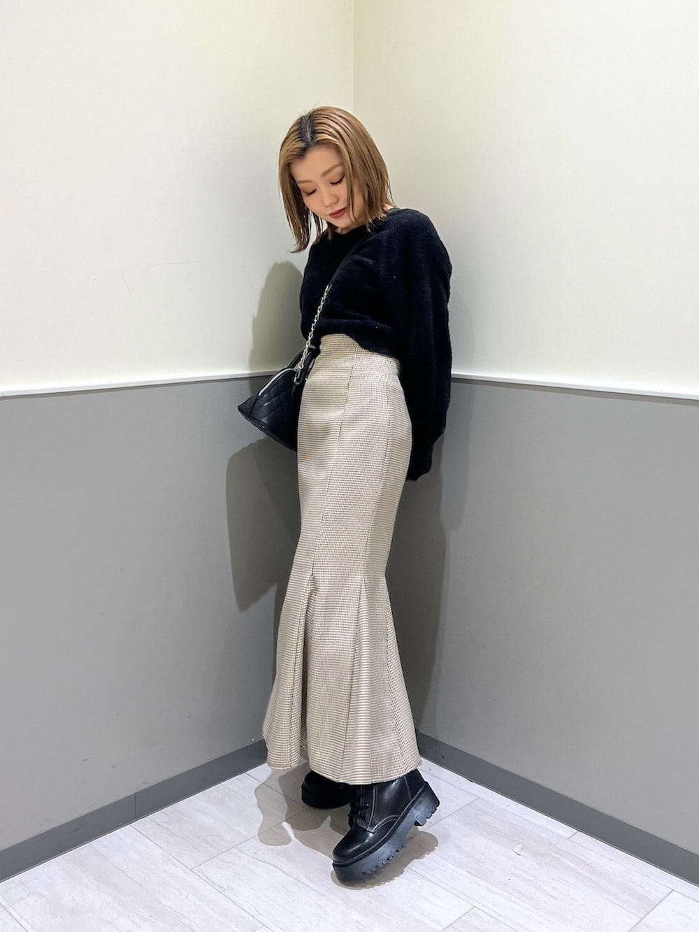 ブラック系のニット/セーター、その他のスカート、ブラック系のブーツを着用したレディースの冬コーディネートの2枚目の写真