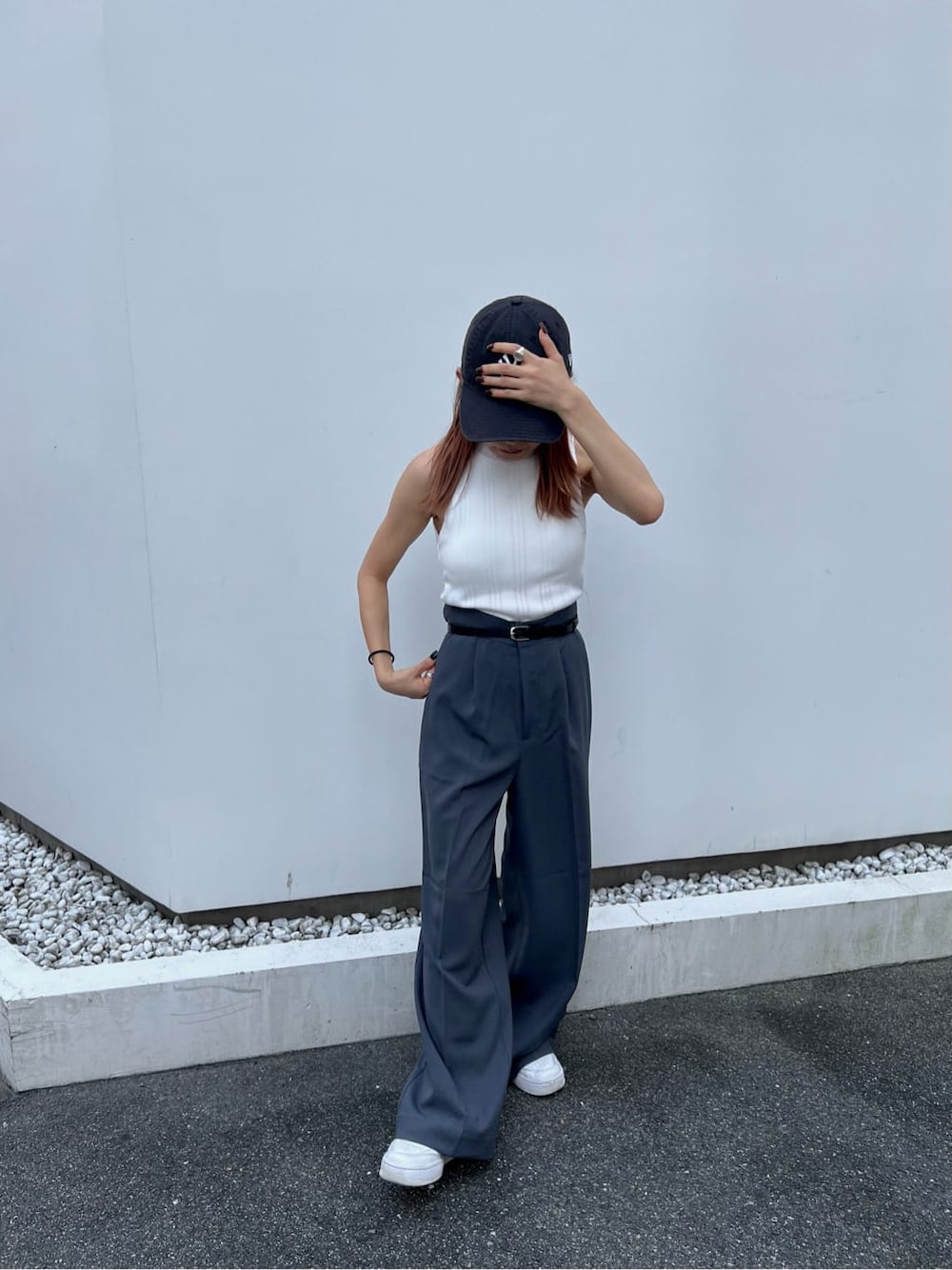 ホワイト系のタンクトップ、グレー系のスラックス、ブラック系のベルトを着用したレディースの夏コーディネートの3枚目の写真