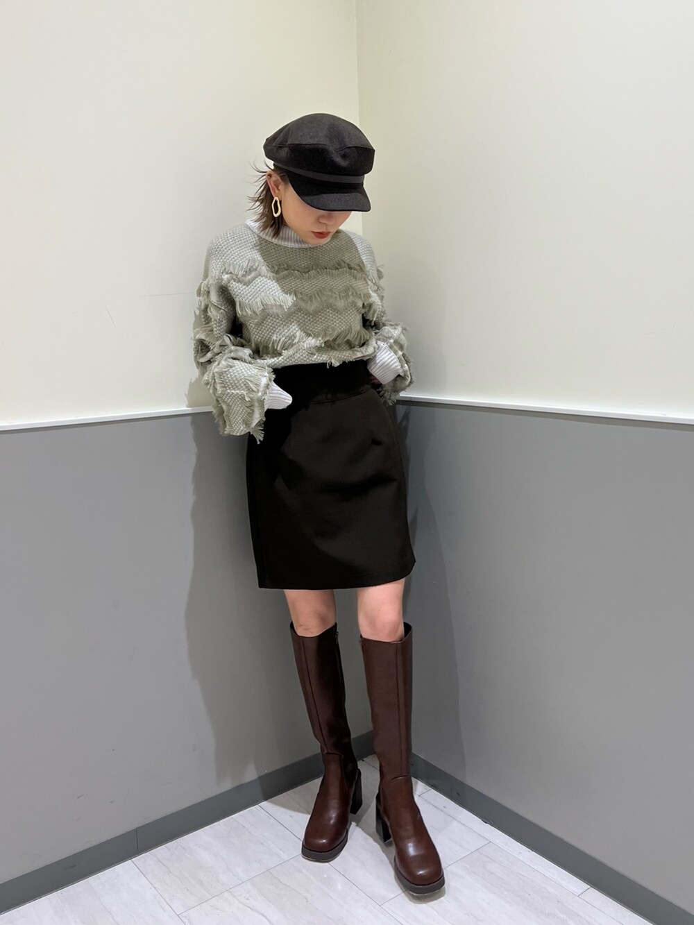 ベージュ系のニット/セーター、ブラウン系のスカート、ブラウン系のブーツを着用したレディースの秋コーディネートの2枚目の写真