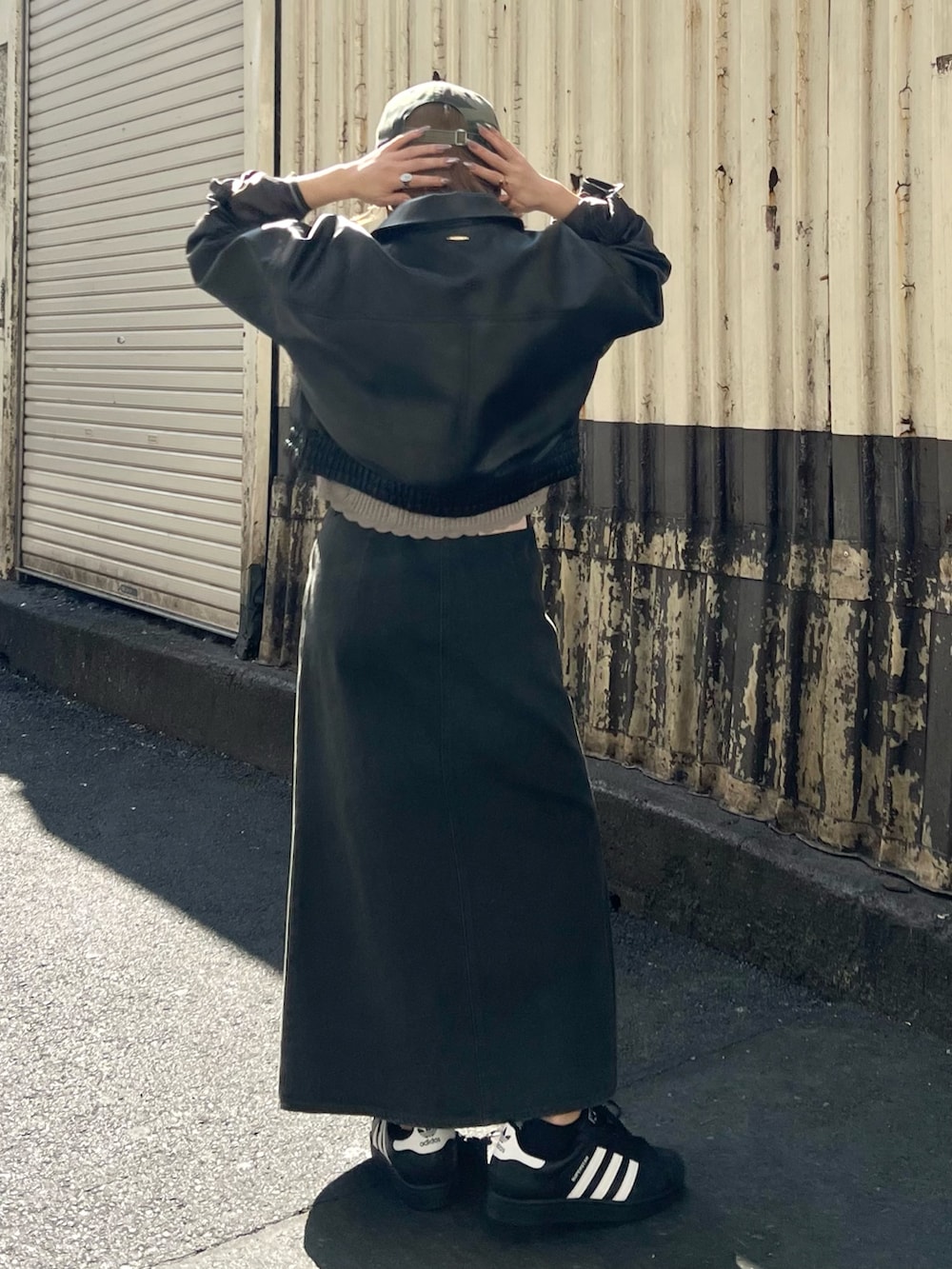 ブラウン系のブルゾン、グレー系のニット/セーター、ブラック系のスカートを着用したレディースの冬コーディネートの3枚目の写真