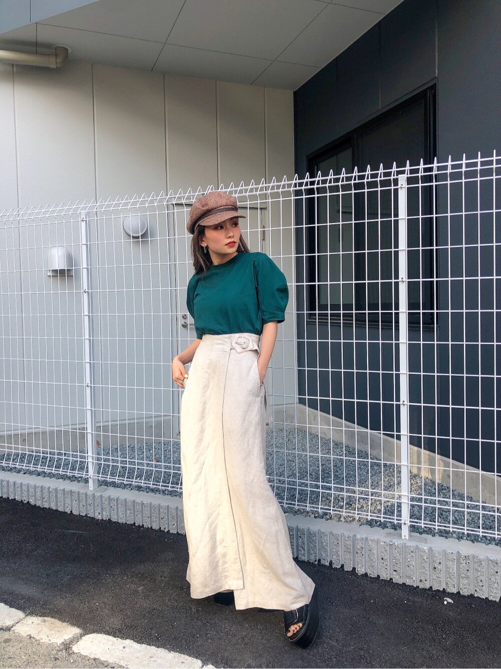 ホワイト系のその他パンツ、グリーン系のTシャツ/カットソー、ブラウン系のキャップを着用したレディースの春コーディネートの2枚目の写真