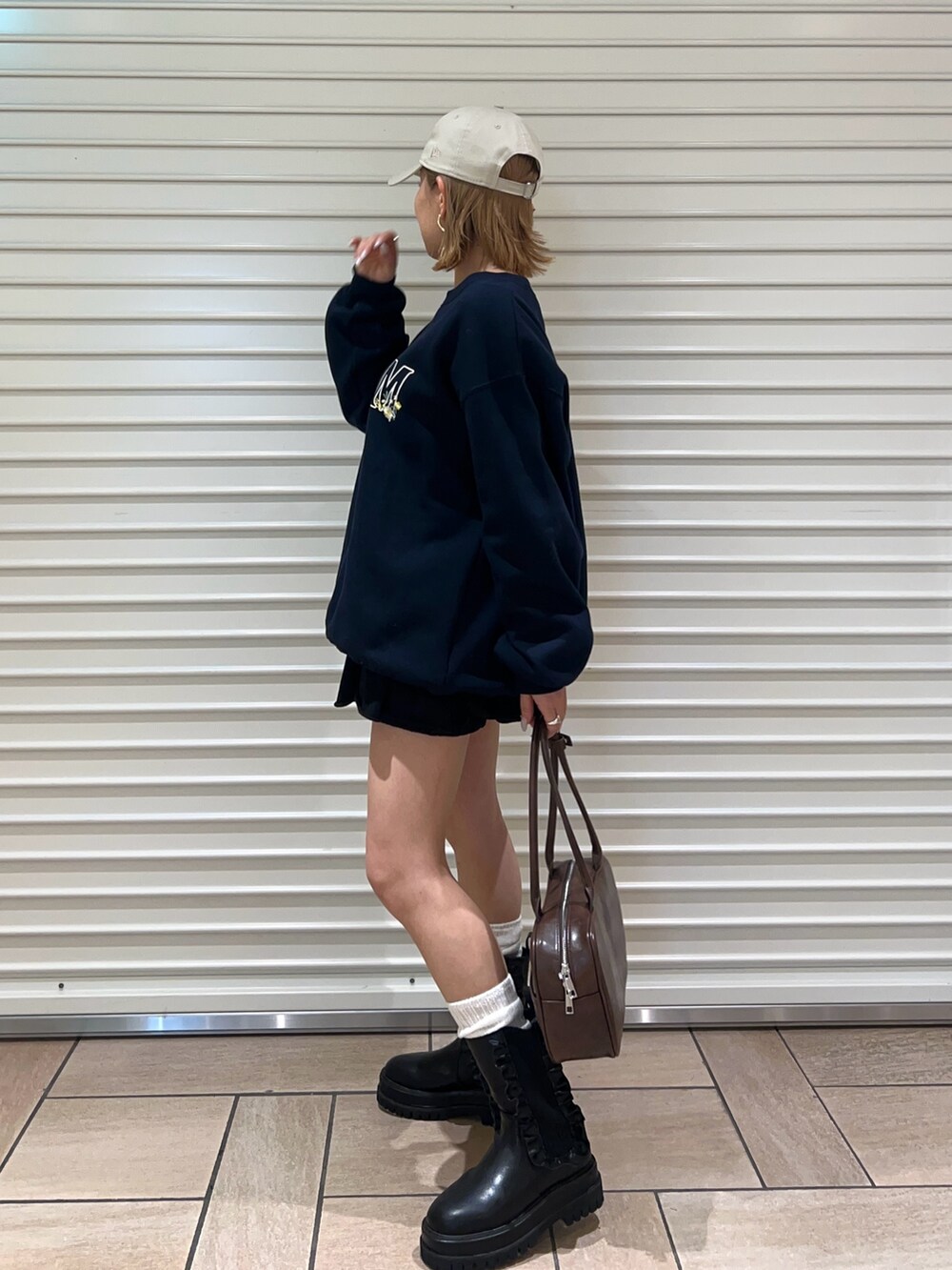 ブラウン系のボストンバッグ、ブラック系のその他パンツ、ブルー系のスウェットを着用したレディースの冬コーディネートの2枚目の写真