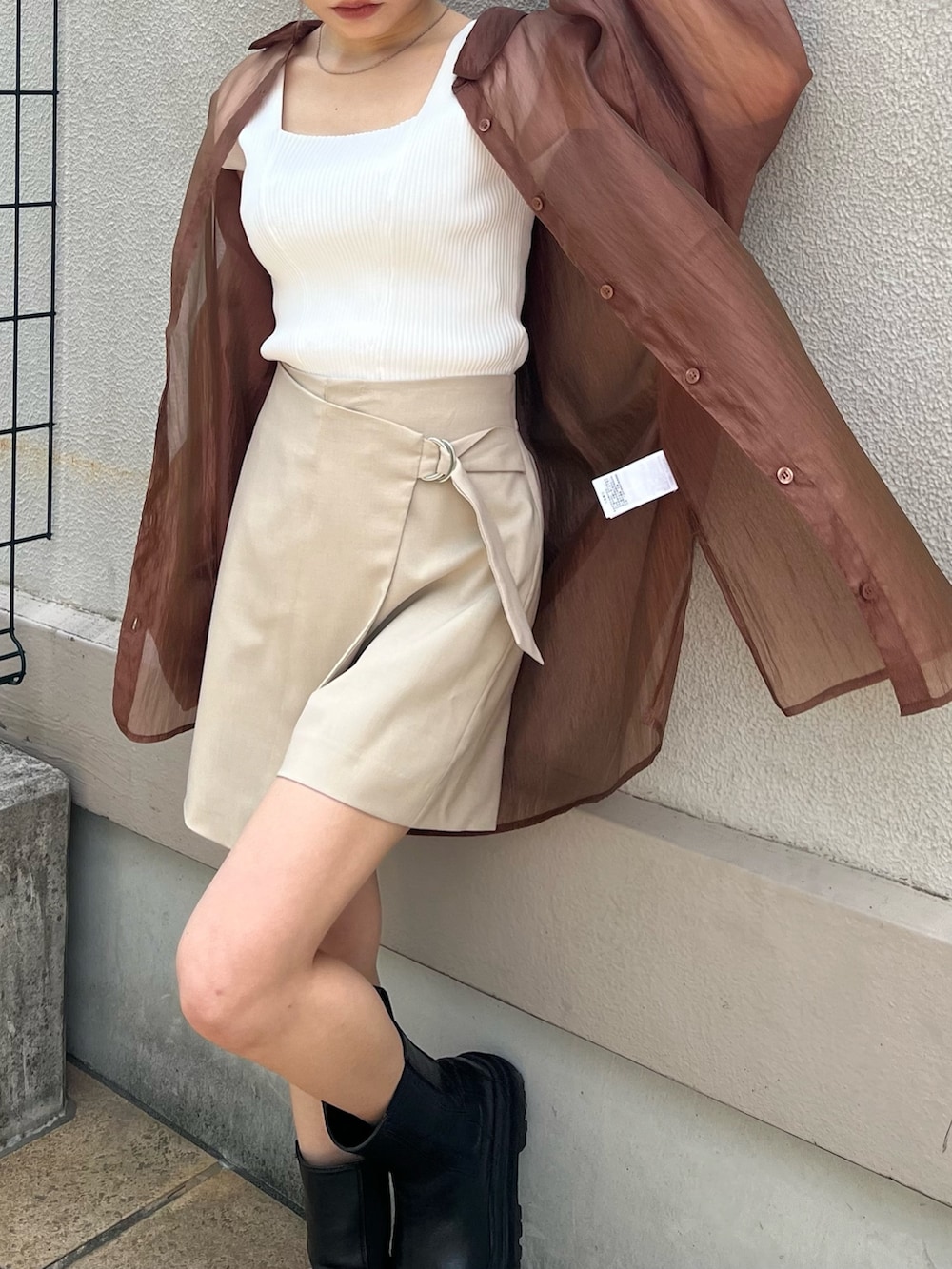 ベージュ系のスラックス、ブラウン系のシャツ/ブラウス、ホワイト系のタンクトップを着用したレディースの春コーディネートの6枚目の写真