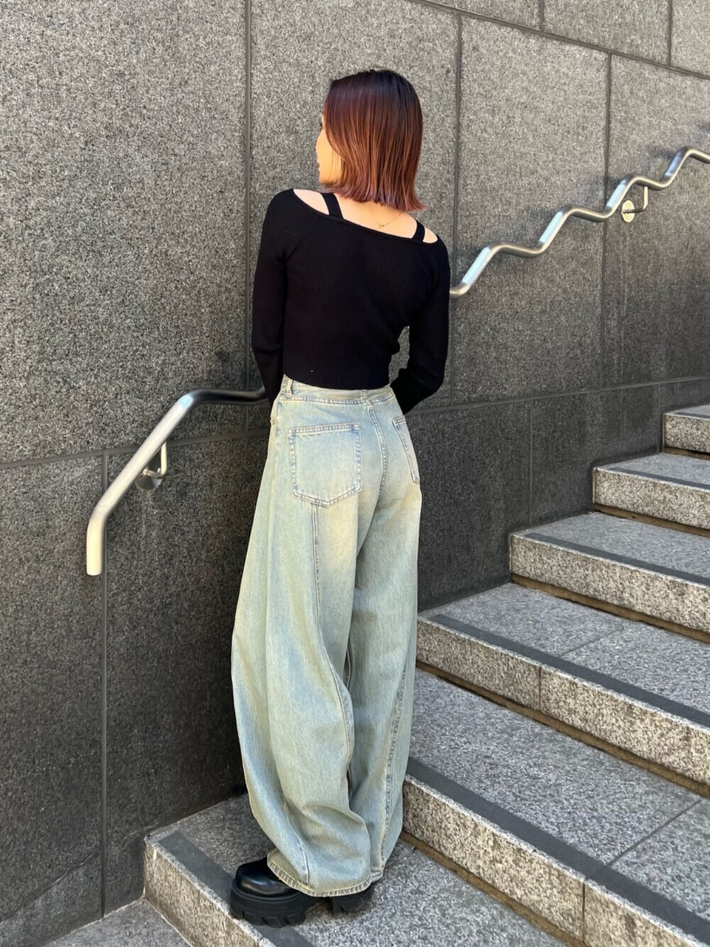 ブルー系のデニムパンツ、ブラック系のニット/セーターを着用したレディースの冬コーディネートの2枚目の写真