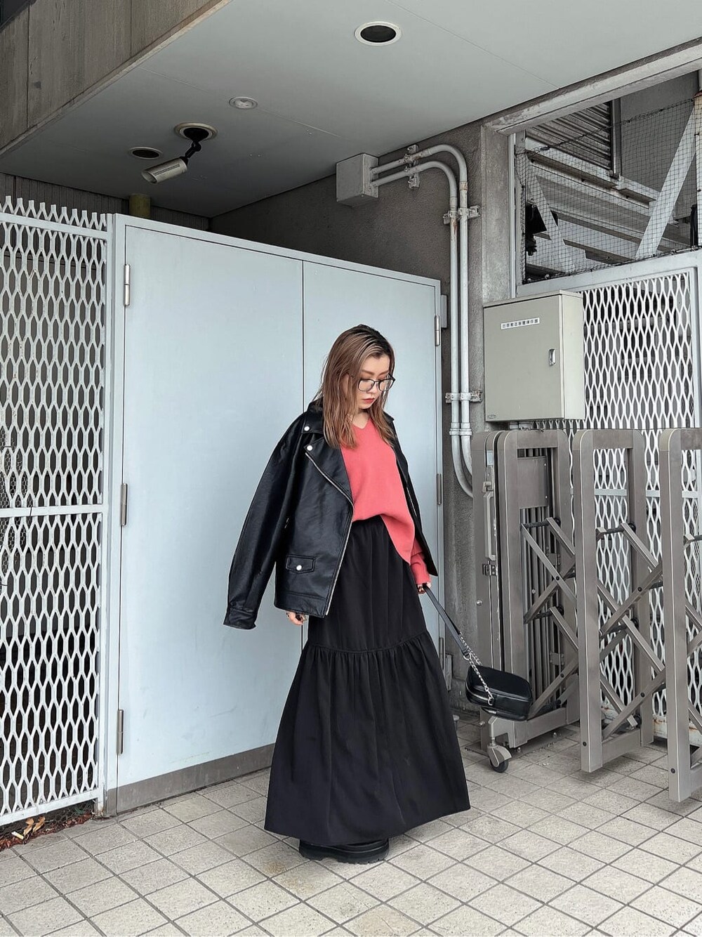 ブラック系のスカート、ブラック系のショルダーバッグ、ピンク系のニット/セーターを着用したレディースの秋コーディネートの3枚目の写真