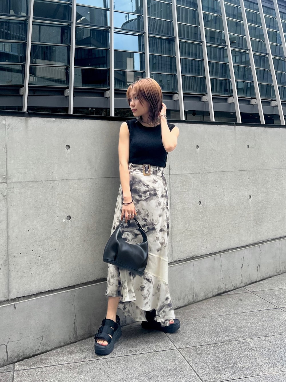 ブラック系のサンダル、ブラック系のハンドバッグ、その他のスカートを着用したレディースの夏コーディネートの2枚目の写真
