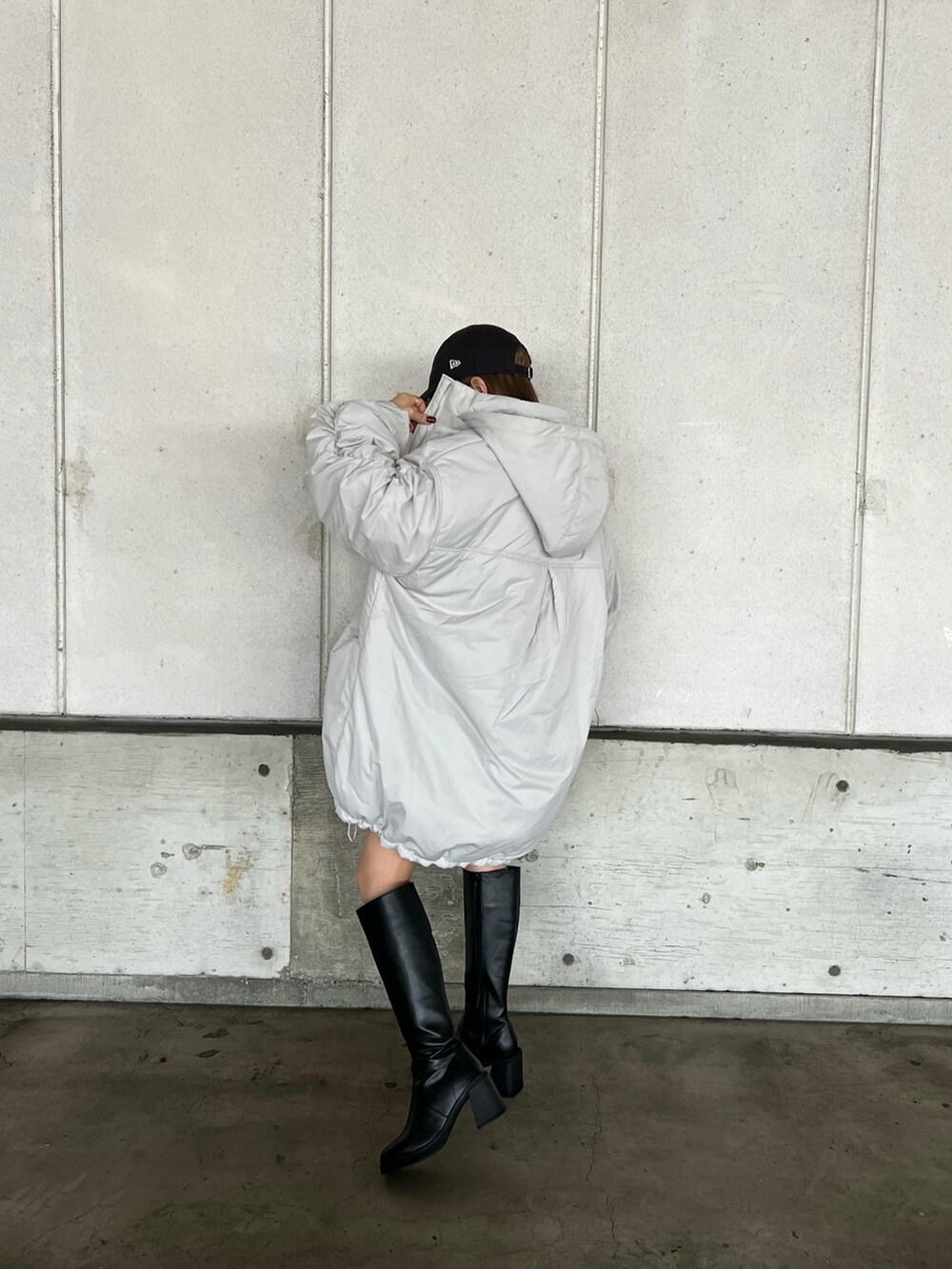 ホワイト系のブルゾン、ブラック系のニット/セーター、グレー系のスウェットパンツを着用したレディースの冬コーディネートの5枚目の写真