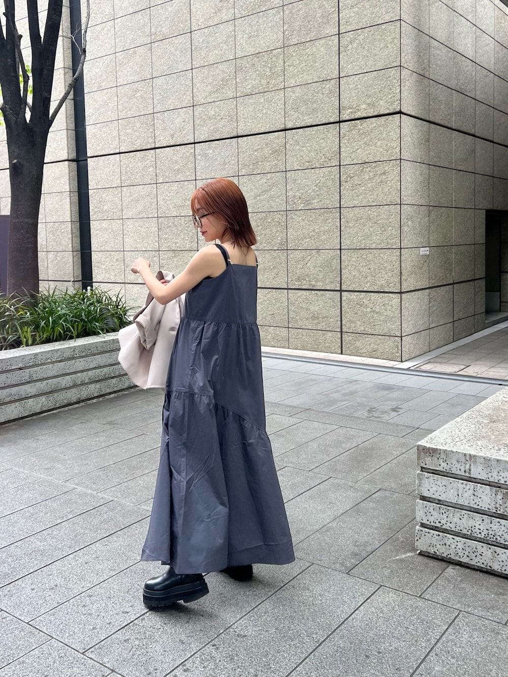 ベージュ系のテーラードジャケット、ブラウン系のニット/セーター、グレー系のワンピースを着用したレディースの春コーディネートの3枚目の写真