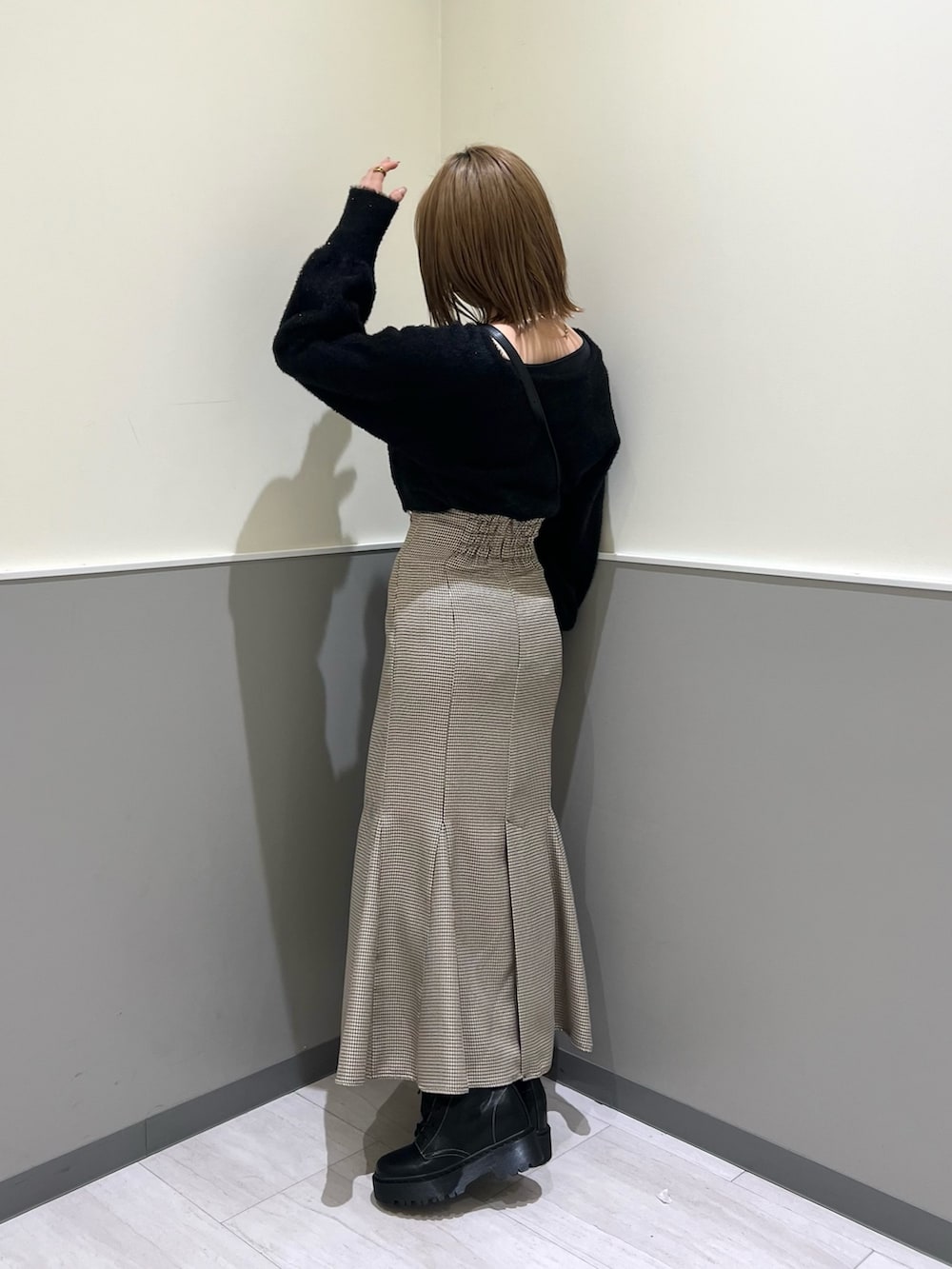 ブラック系のニット/セーター、その他のスカート、ブラック系のブーツを着用したレディースの冬コーディネートの4枚目の写真