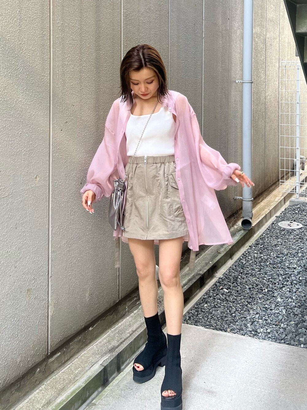 ピンク系のシャツ/ブラウス、ホワイト系のニット/セーター、グレー系のショルダーバッグを着用したレディースの春コーディネートの3枚目の写真